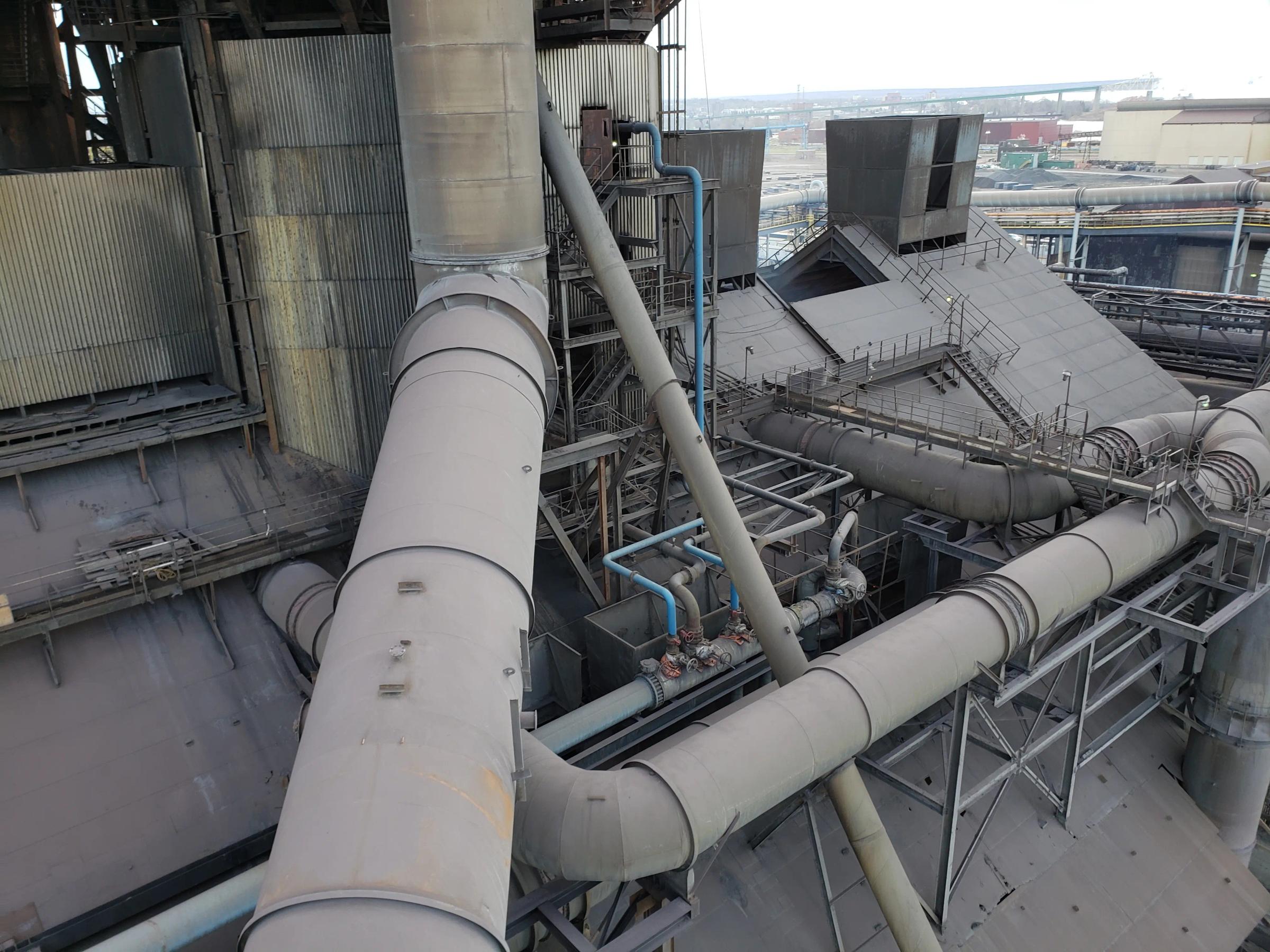 Existing riser main and surrounding industrial piping.