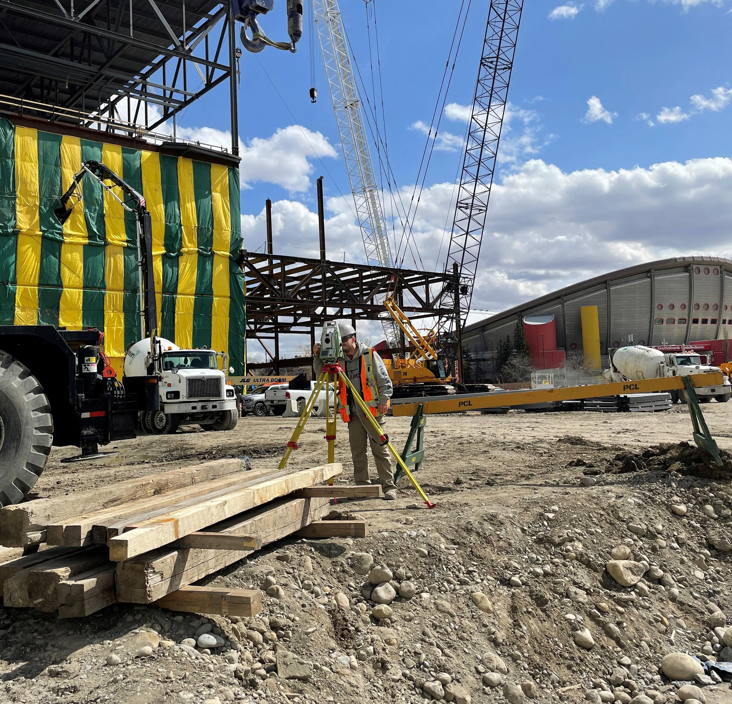 TULLOCH survey equipment set up beside crane and construction activity.