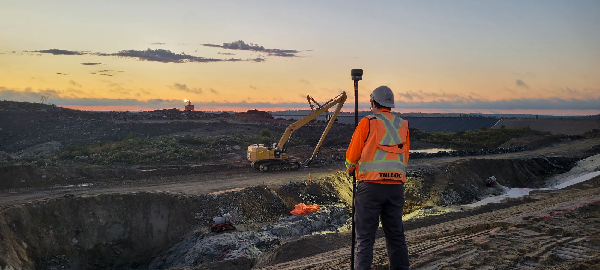 TULLOCH field surveyor working at a mine site near sunset.