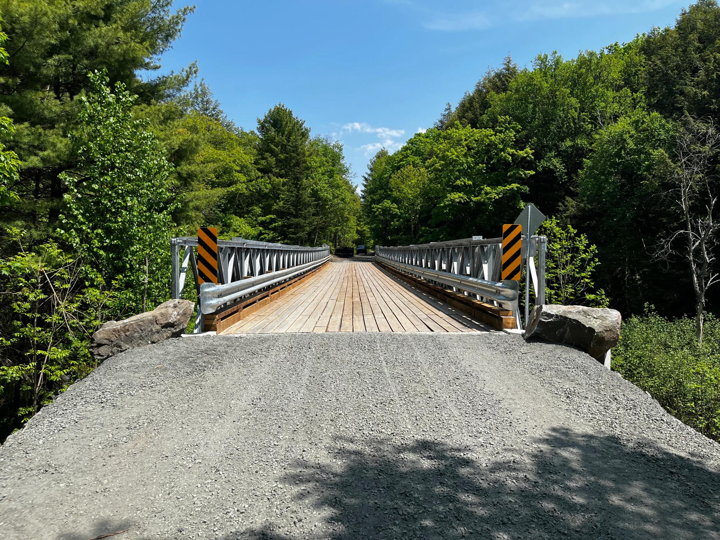 Completed Seguin Bridge 27 replacement on a gravel road in a forested setting.