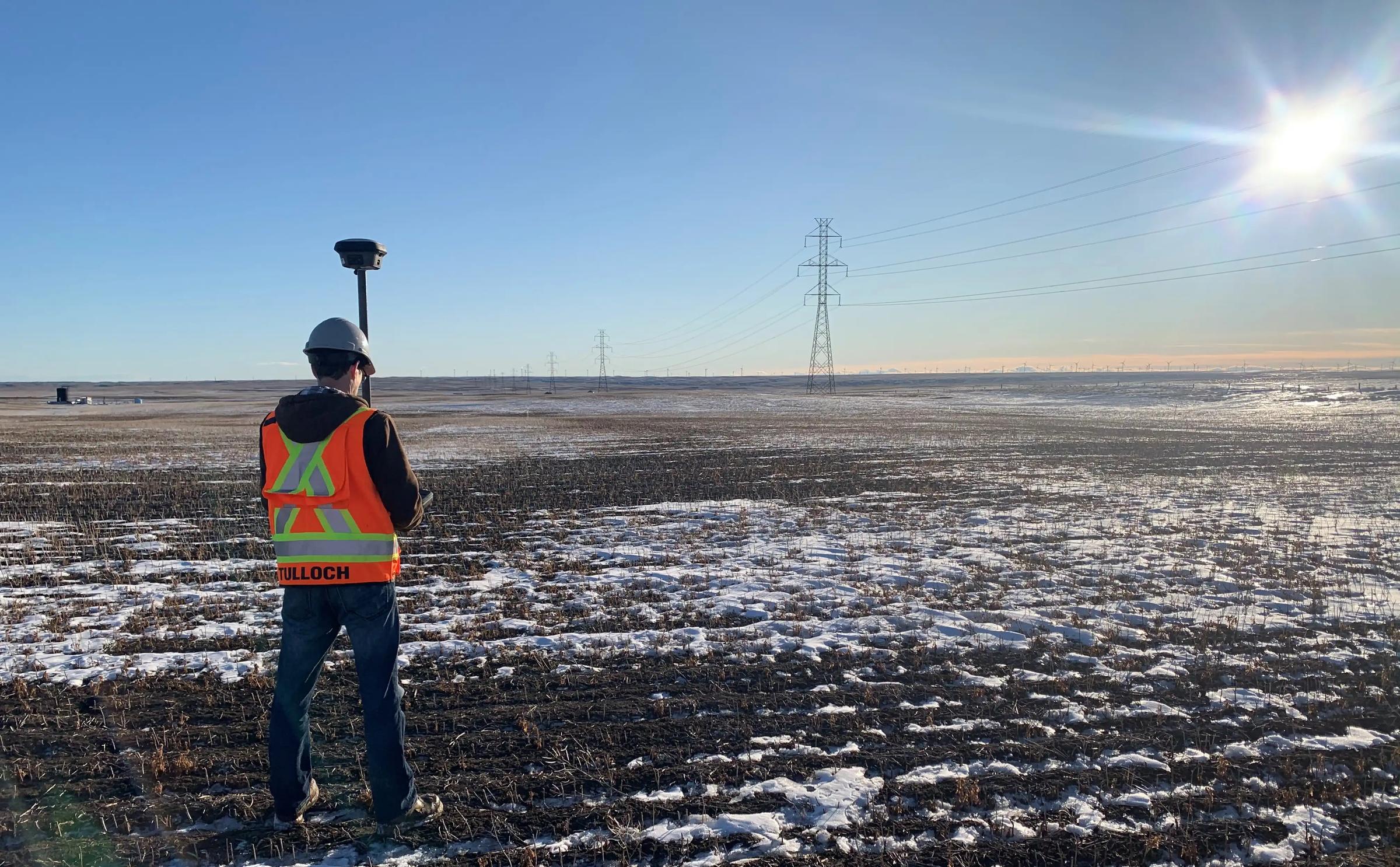 TULLOCH geomatics field technician collecting survey data on an energy project.