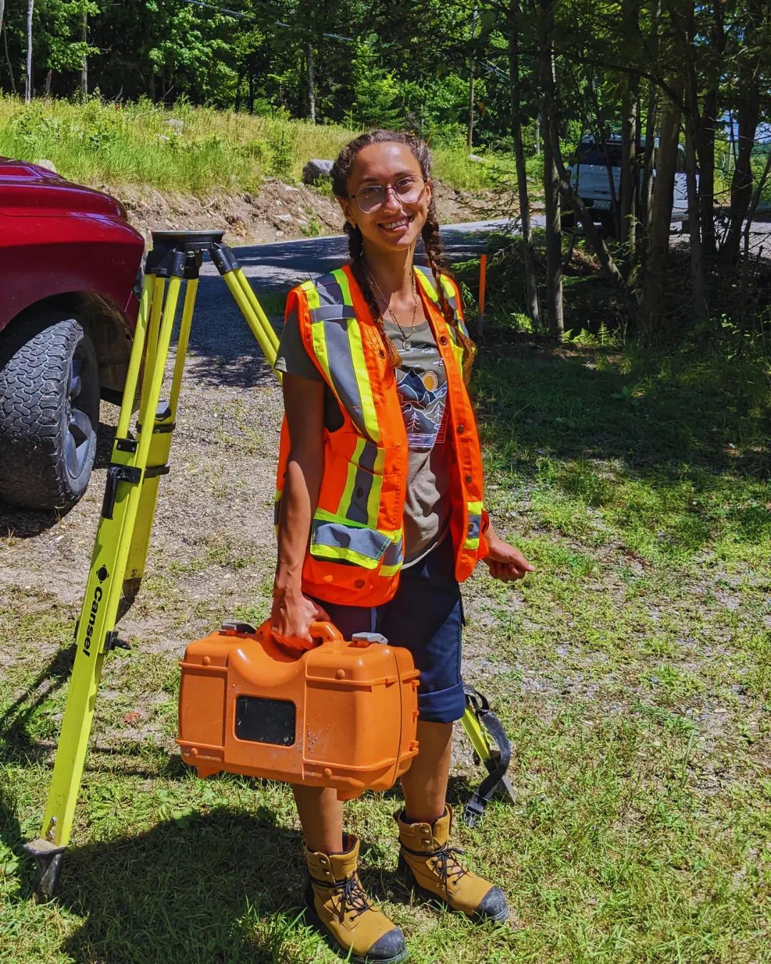 TULLOCH land surveyor standing beside survey equipment in the field.