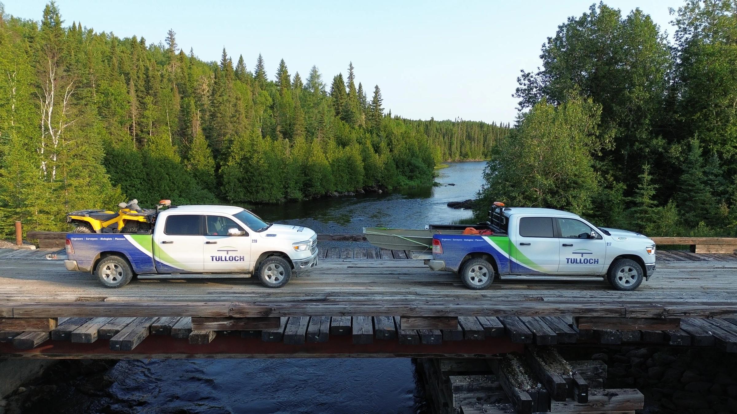 TULLOCH vehicles and field crew working near a remote bridge crossing.