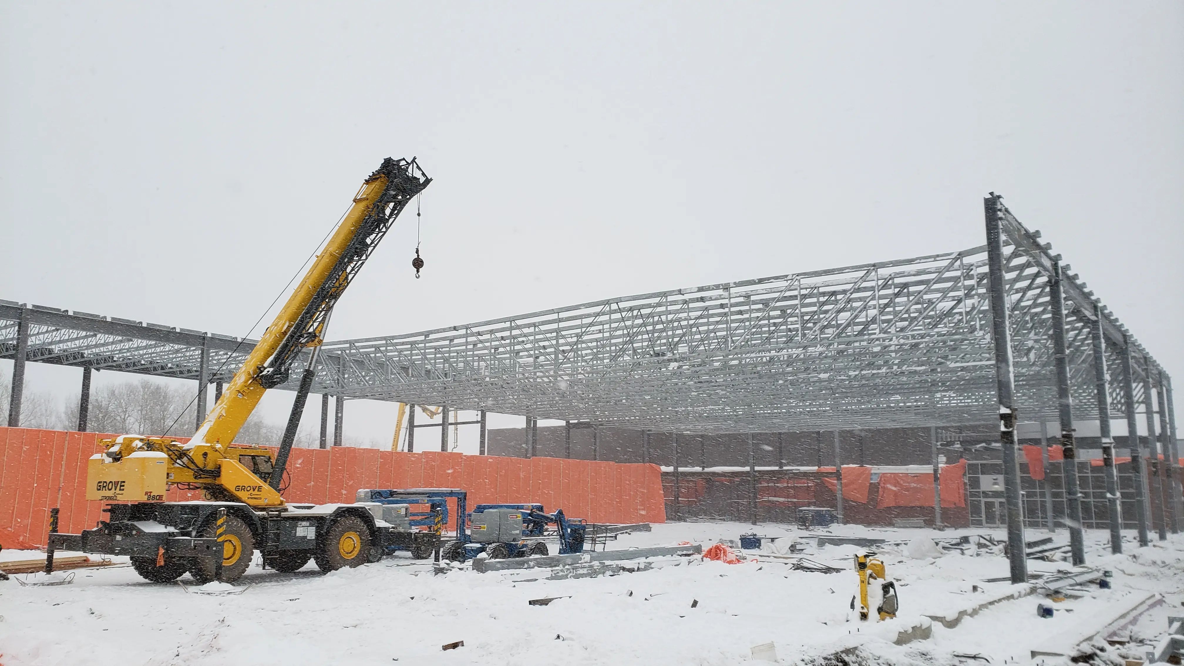 Steel-framed building under construction during winter conditions.