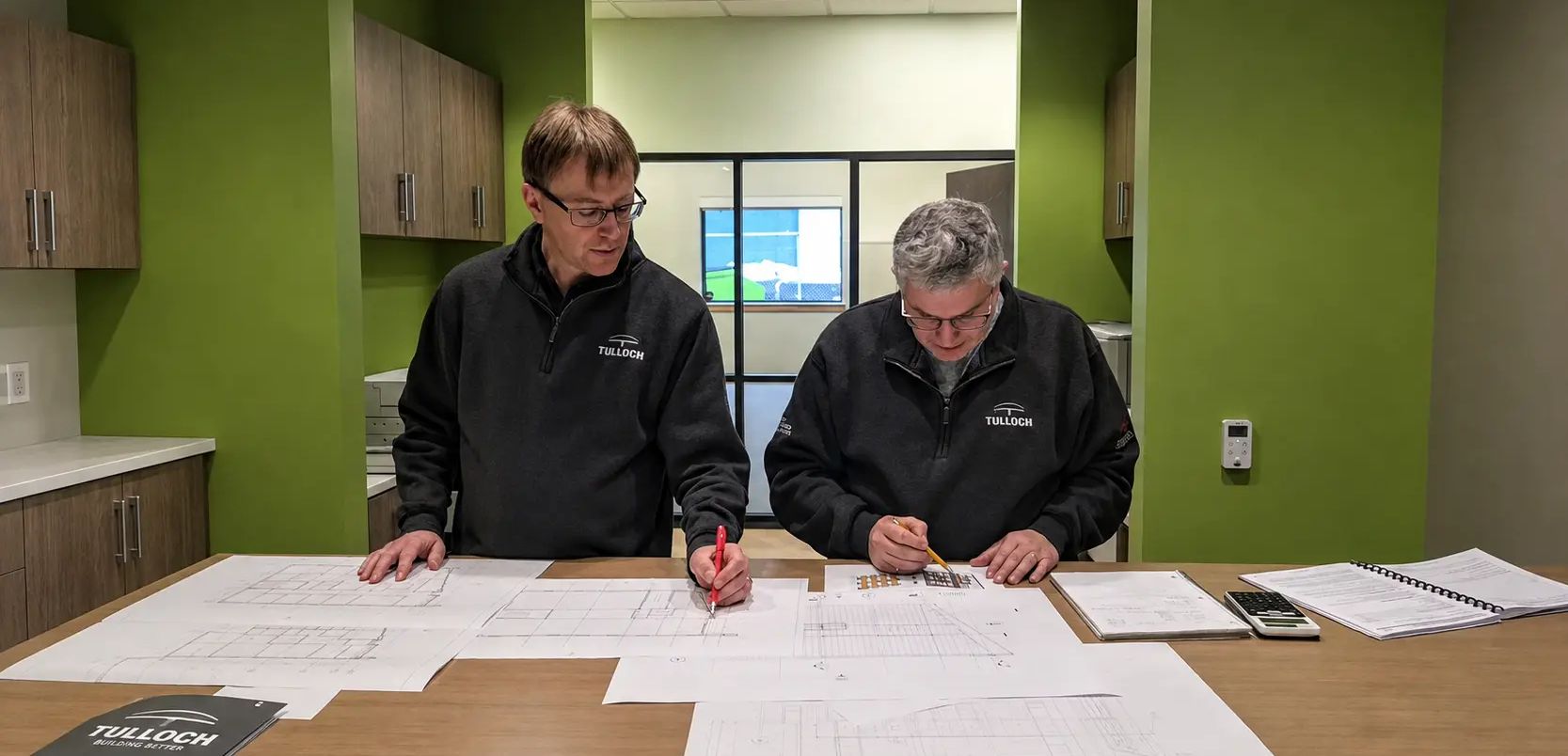 Heavy industry engineering team reviewing drawings in office.
