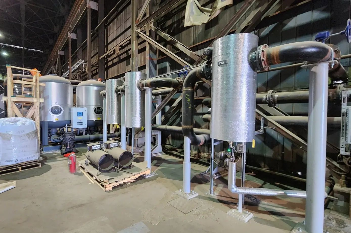 Mechanical equipment and piping inside an industrial pump house.