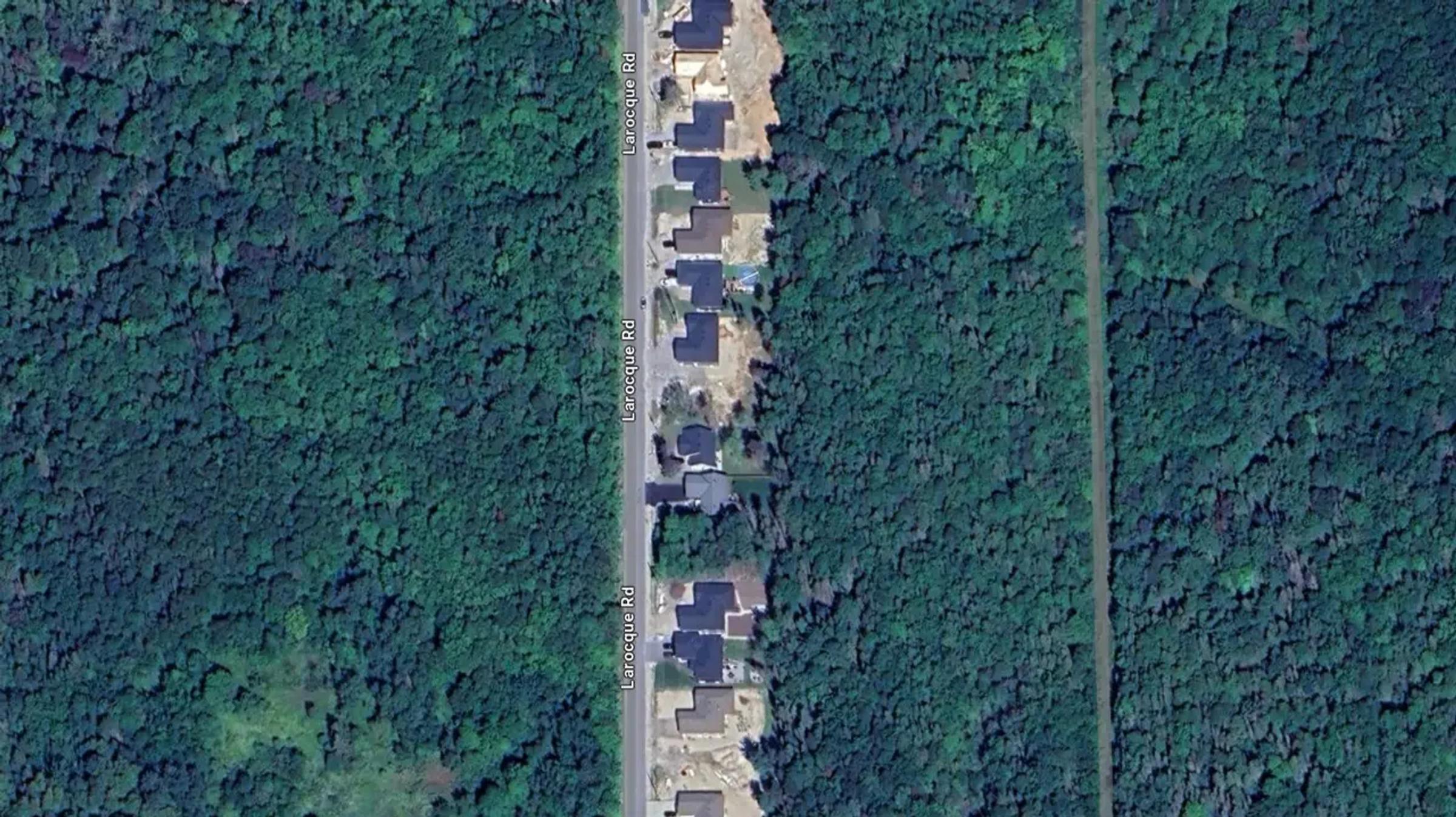 Top-down aerial view of a North Bay road corridor through a forested area.