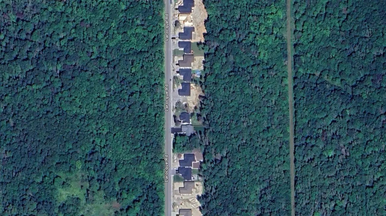 Top-down aerial view of a North Bay road corridor through a forested area.