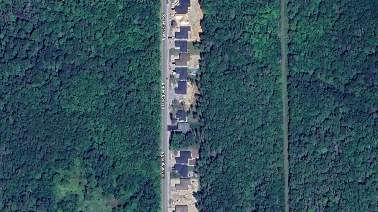 Top-down aerial view of a North Bay road corridor through a forested area.