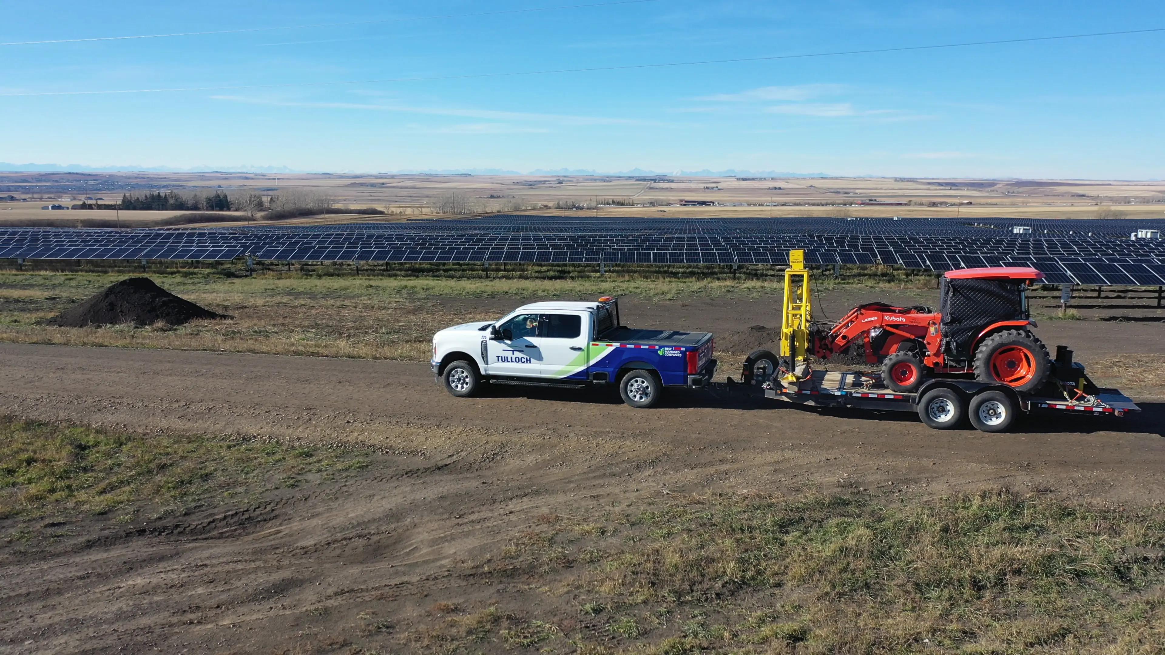 TULLOCH truck, trailer, and solar pile testing tractor at a utility-scale solar site.
