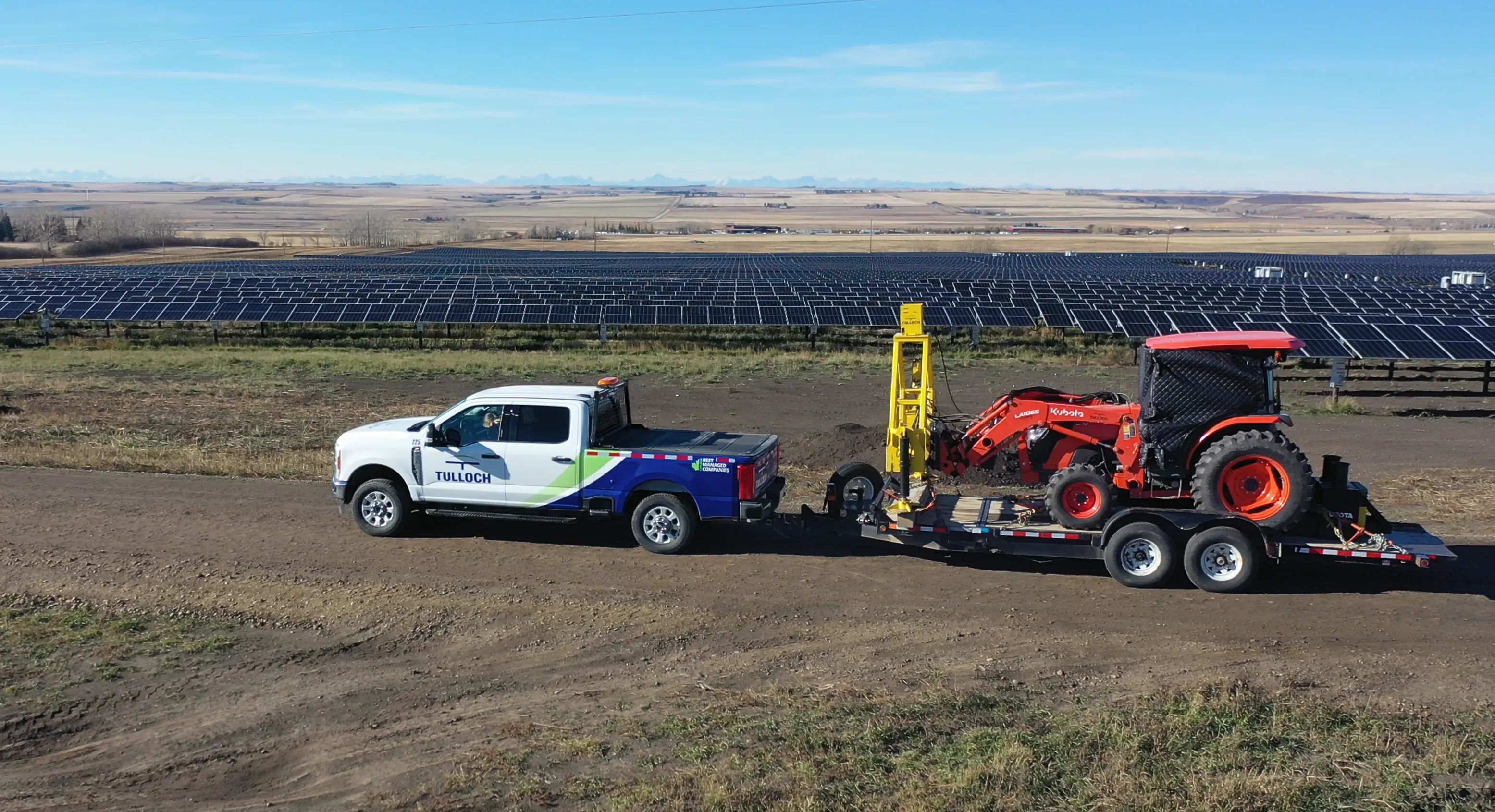 TULLOCH truck, trailer, and solar pile testing tractor at a utility-scale solar site.