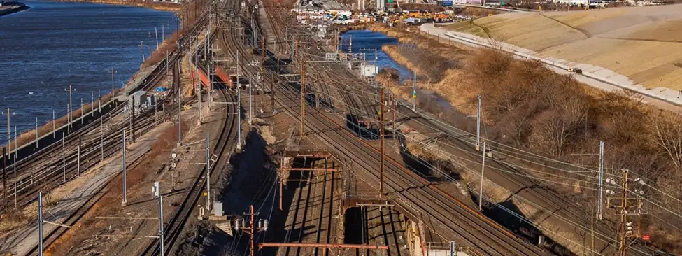Aerial view of an Amtrak rail corridor and surrounding transportation infrastructure.