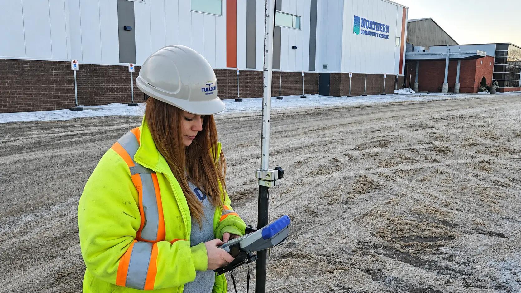 TULLOCH field technician using survey equipment at an industrial site.