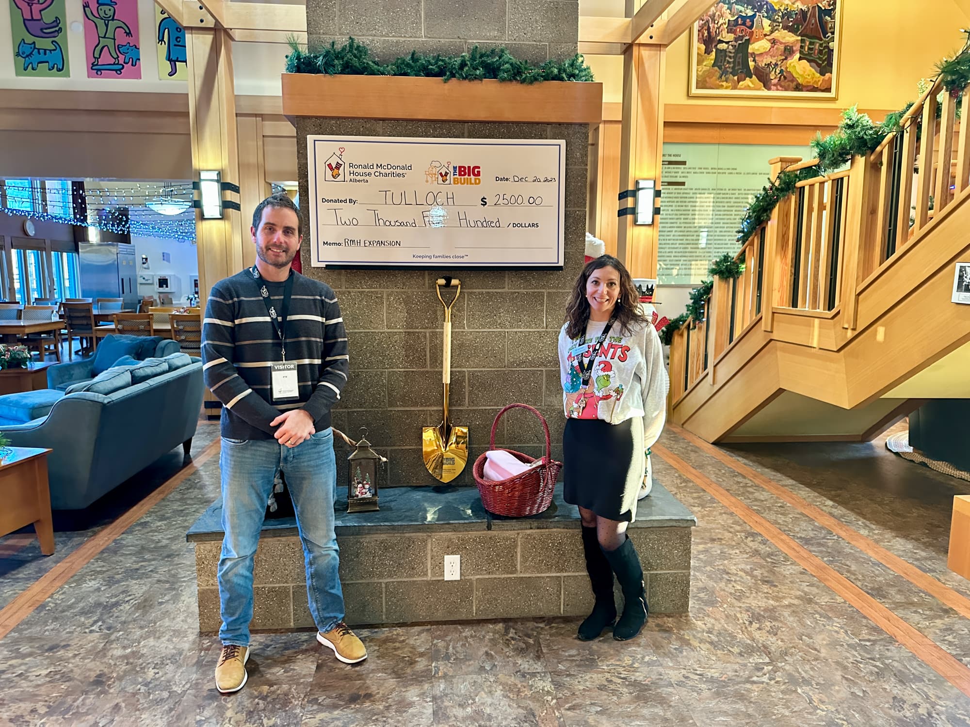 Posing in front of TULLOCH donation cheque at Ronald McDonald House Charities in Calgary.