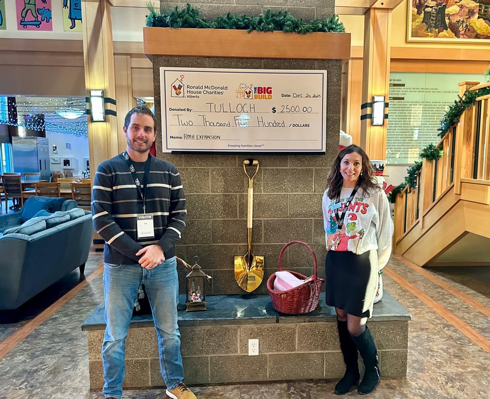 Posing in front of TULLOCH donation cheque at Ronald McDonald House Charities in Calgary.