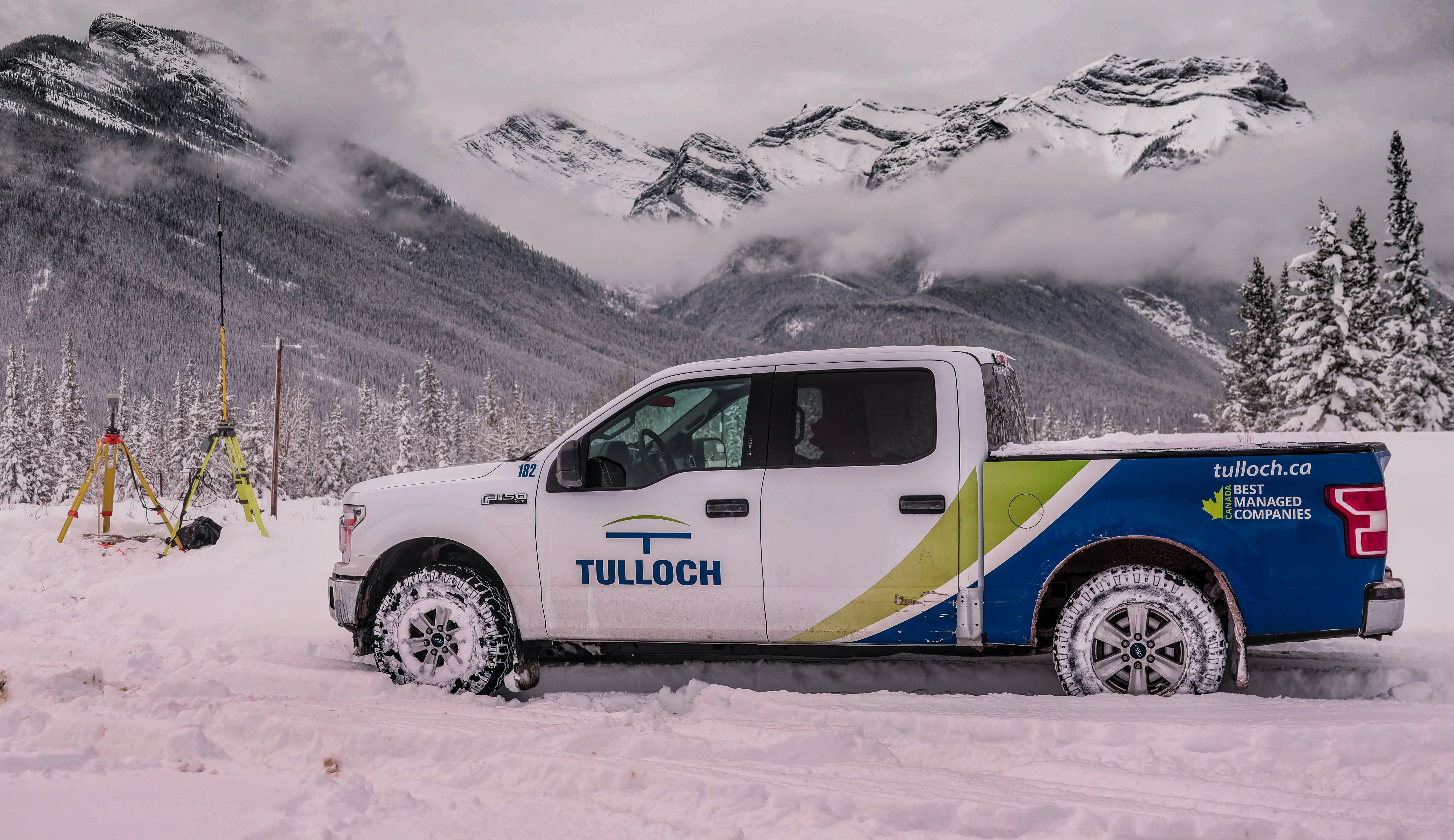 TULLOCH company truck at a winter project site in the Alberta Rockies.