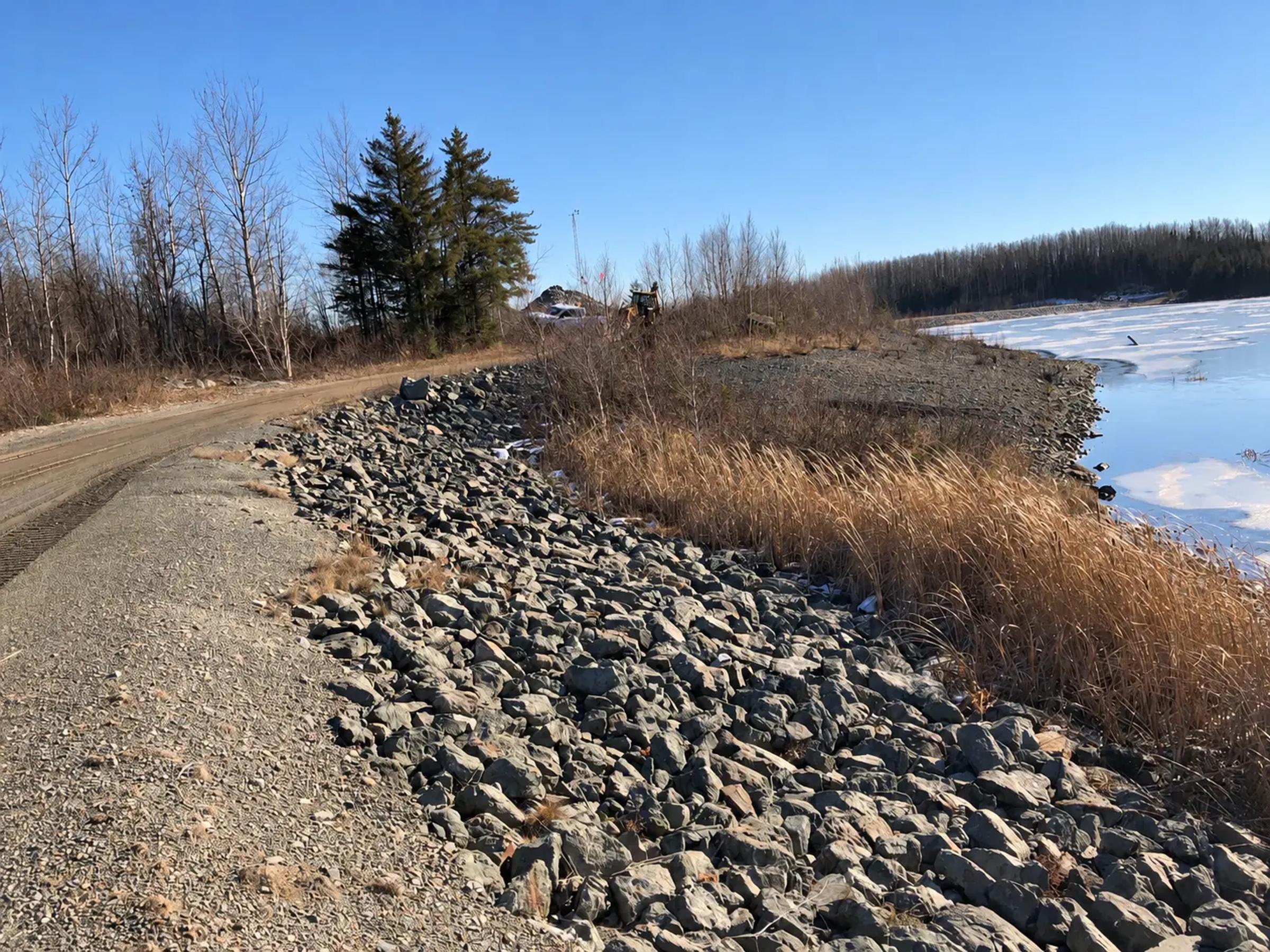 Riprap embankment and access road at Shebandowan Mine during a dam safety review.