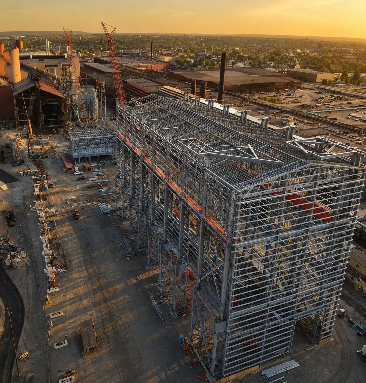 Construction of an electric arc furnace facility at an industrial site.