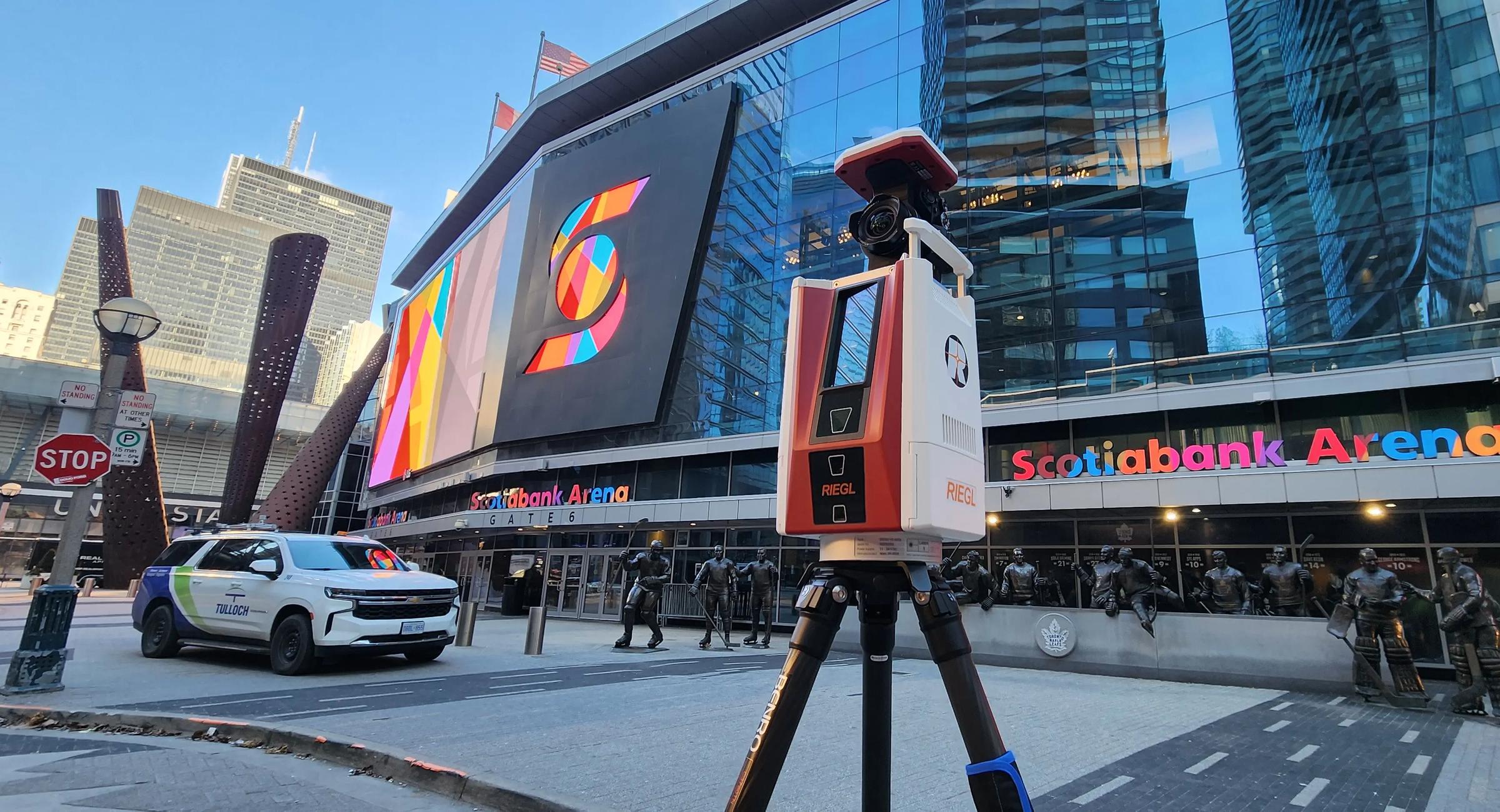 Static LiDAR scanner set up beside rail infrastructure in an urban station area.