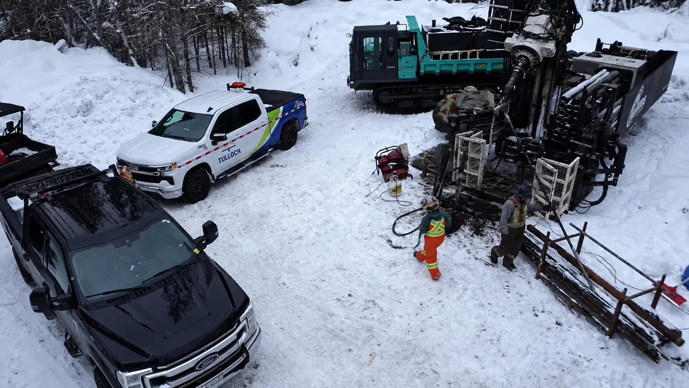 TULLOCH field crew and vehicles working beside drilling equipment in winter.