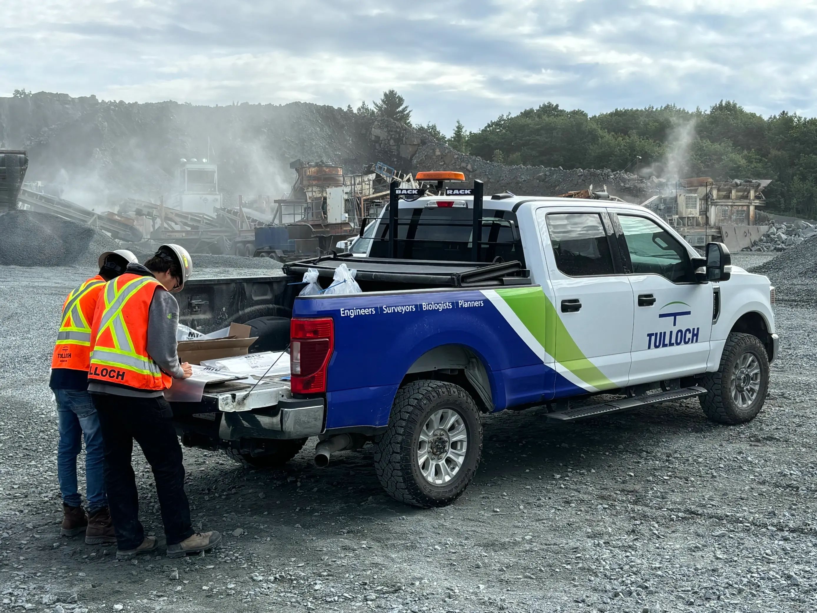 TULLOCH field technicians preparing equipment at the tailgate of a company truck.