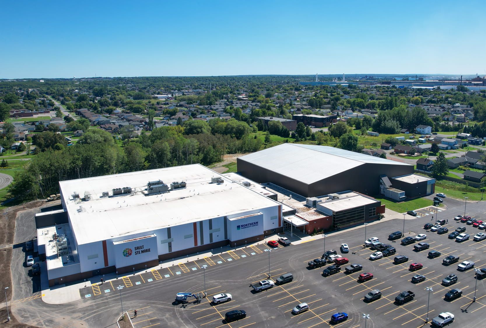 Aerial view of a commercial building and surrounding site.