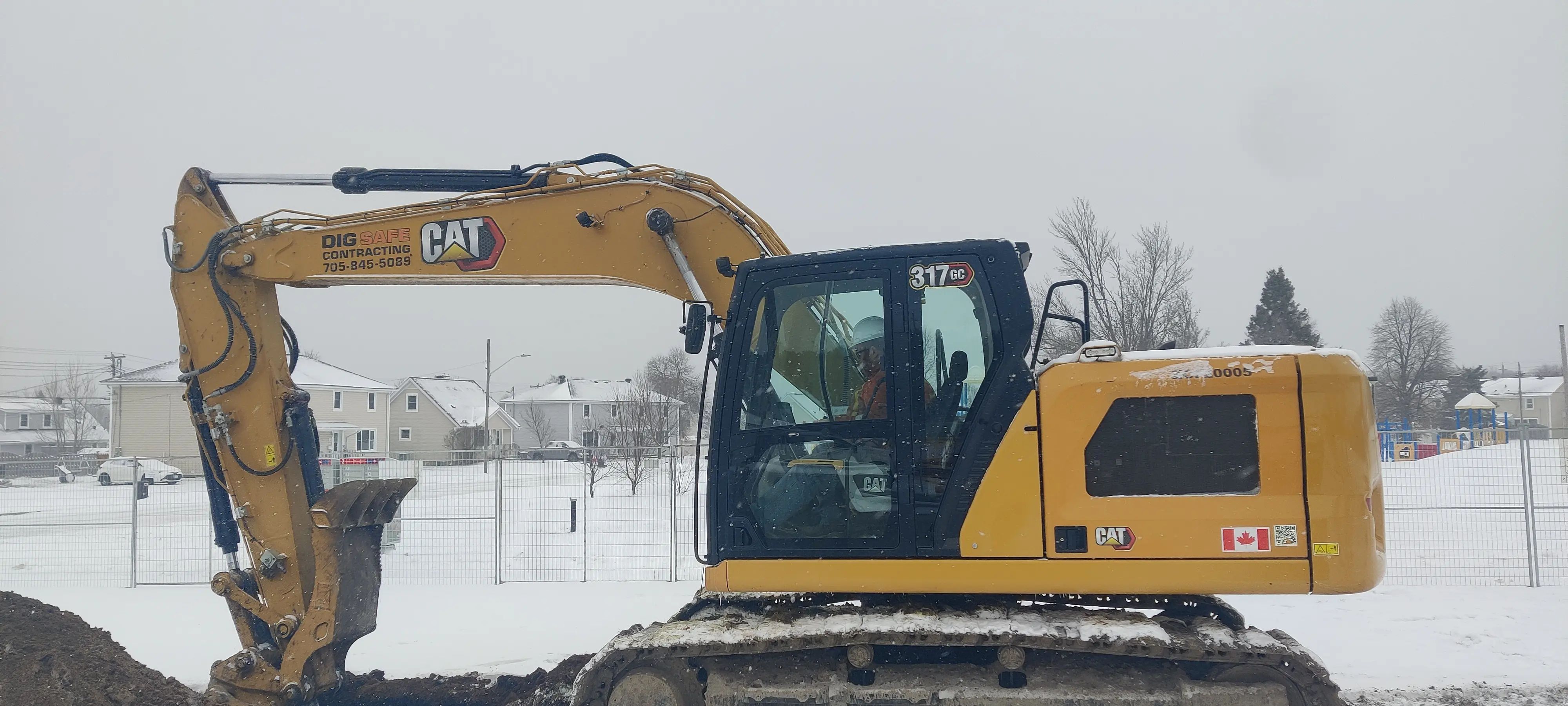 Excavator supporting Phase II Environmental Site Assessment fieldwork at a Sudbury industrial property.