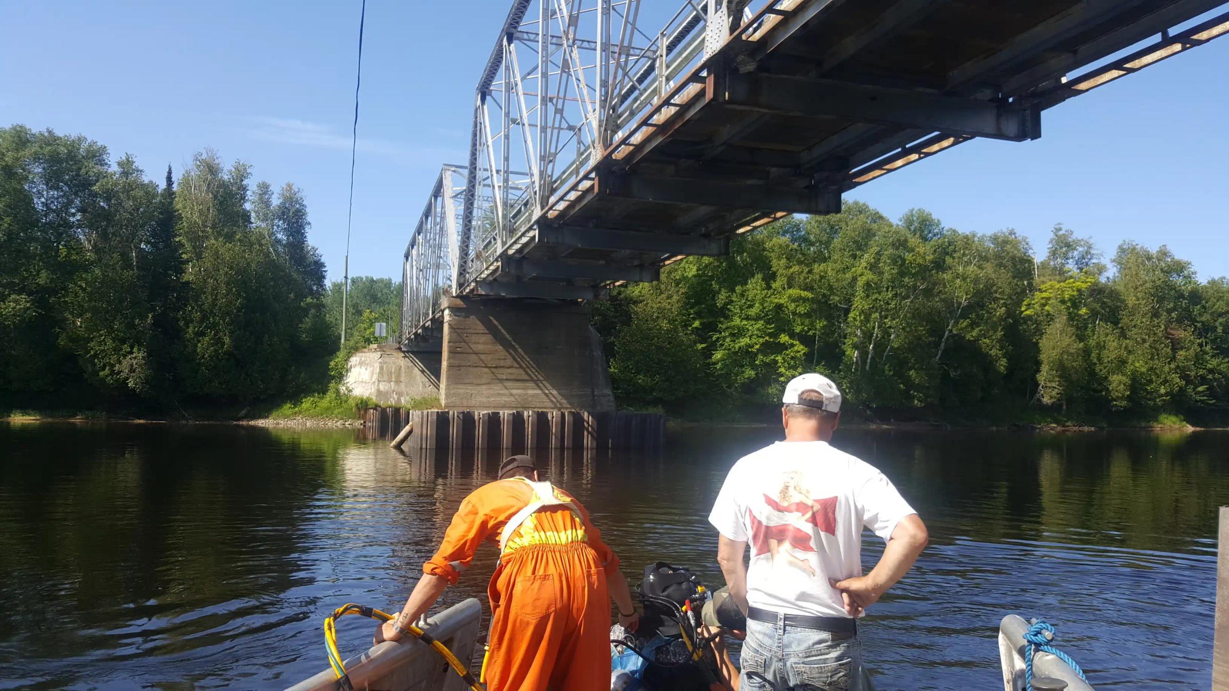 TULLOCH field staff reviewing a municipal bridge over a waterway.
