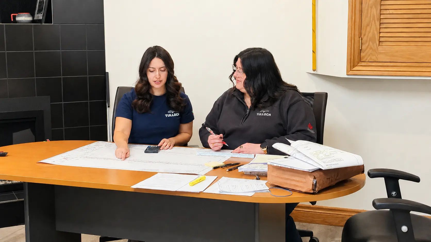 TULLOCH team members collaborating on land development documents in an office.