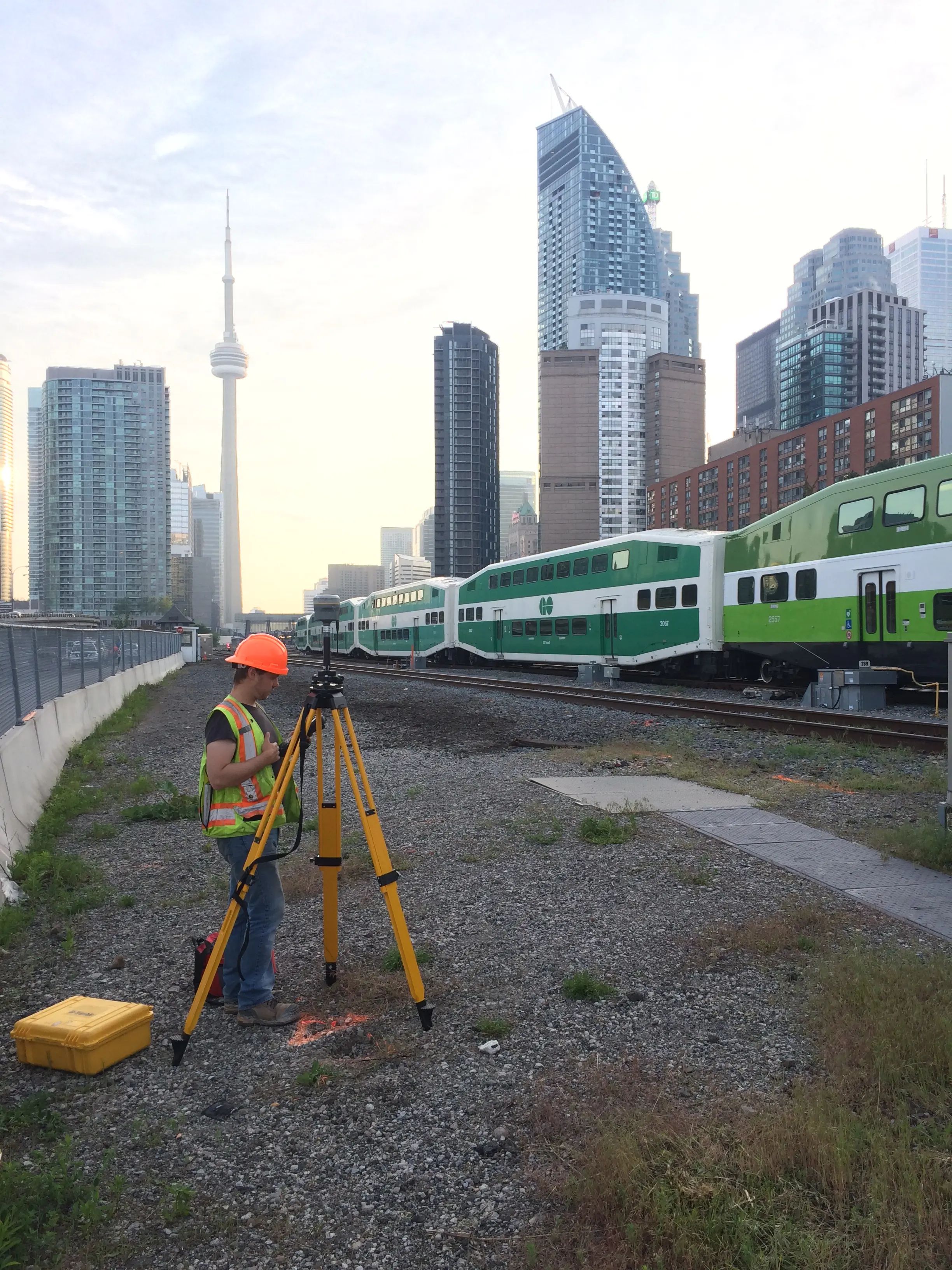 TULLOCH field technician operating survey equipment beside an active rail corridor.