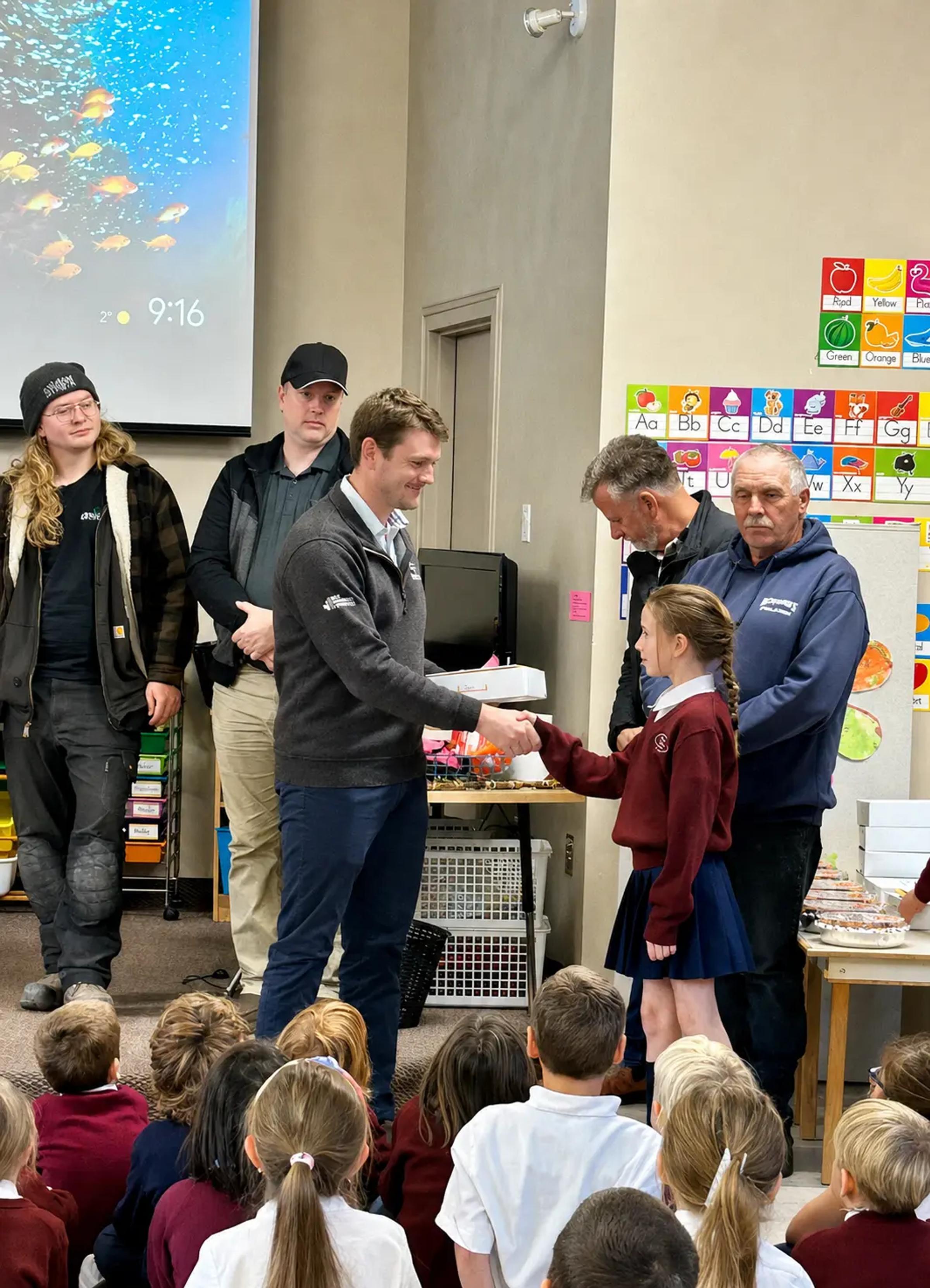TULLOCH staff member accepting gift from Muskoka Christian School student.