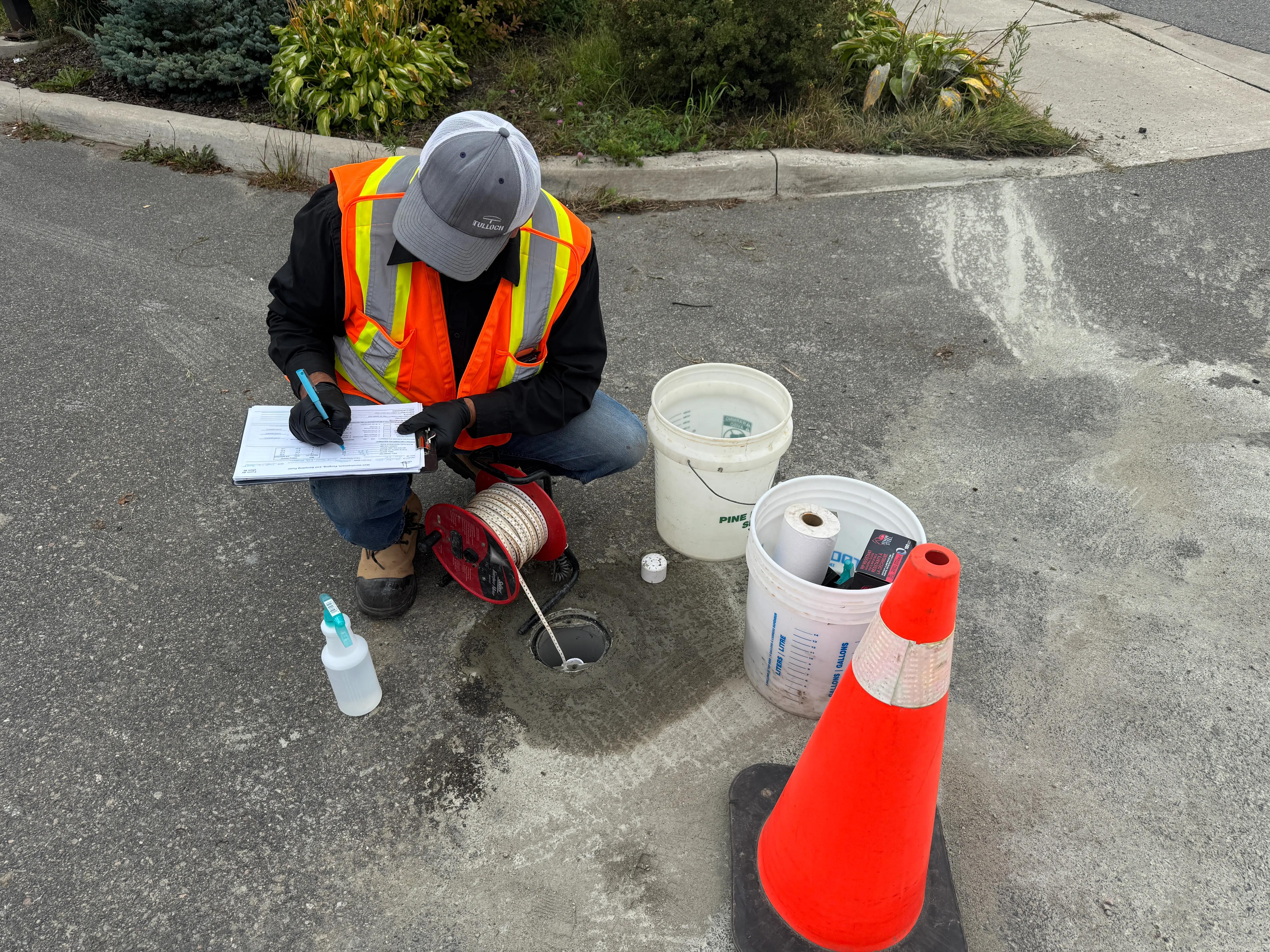 TULLOCH field technician recording test information beside sampling equipment.