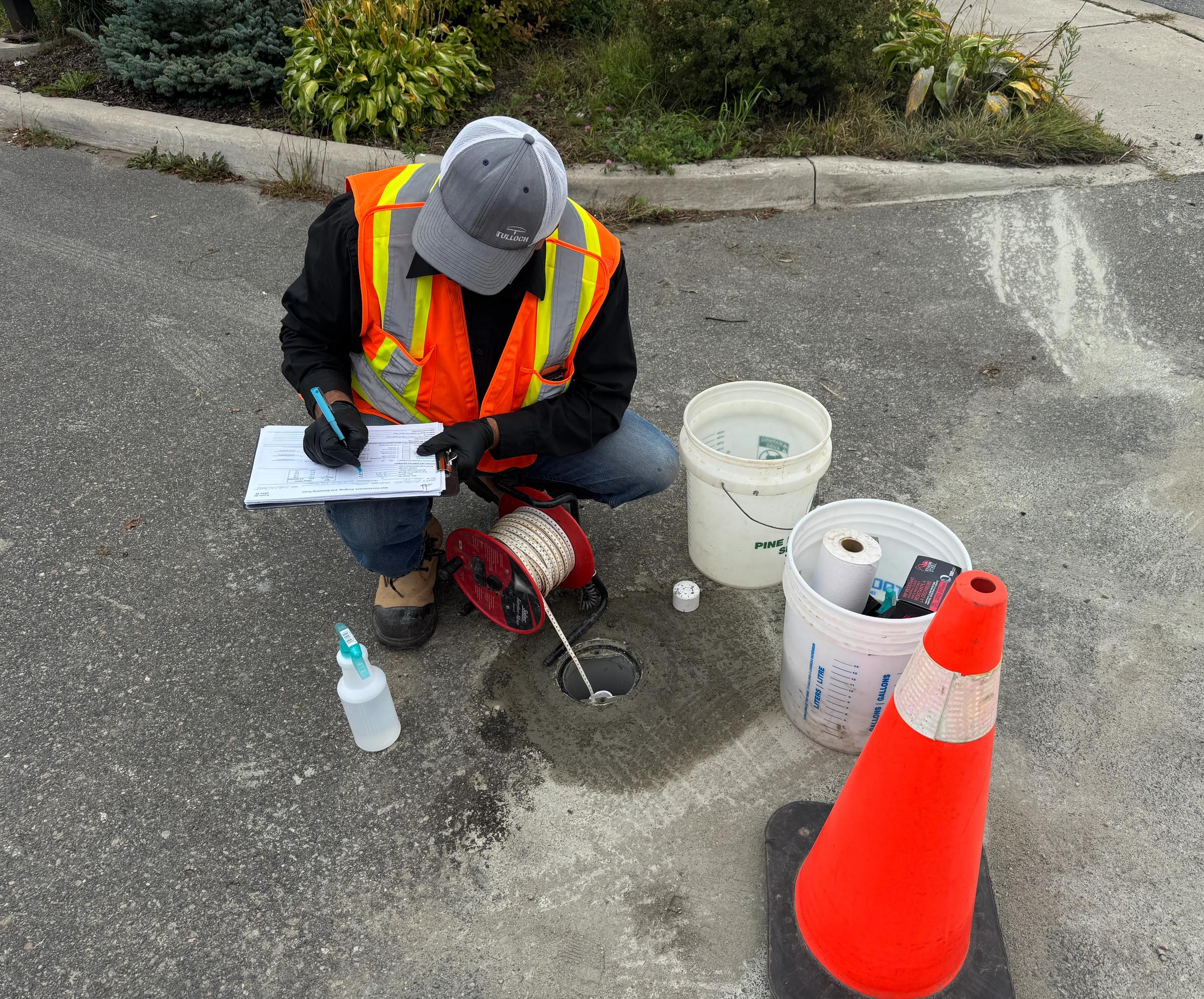 TULLOCH field technician recording test information beside sampling equipment.
