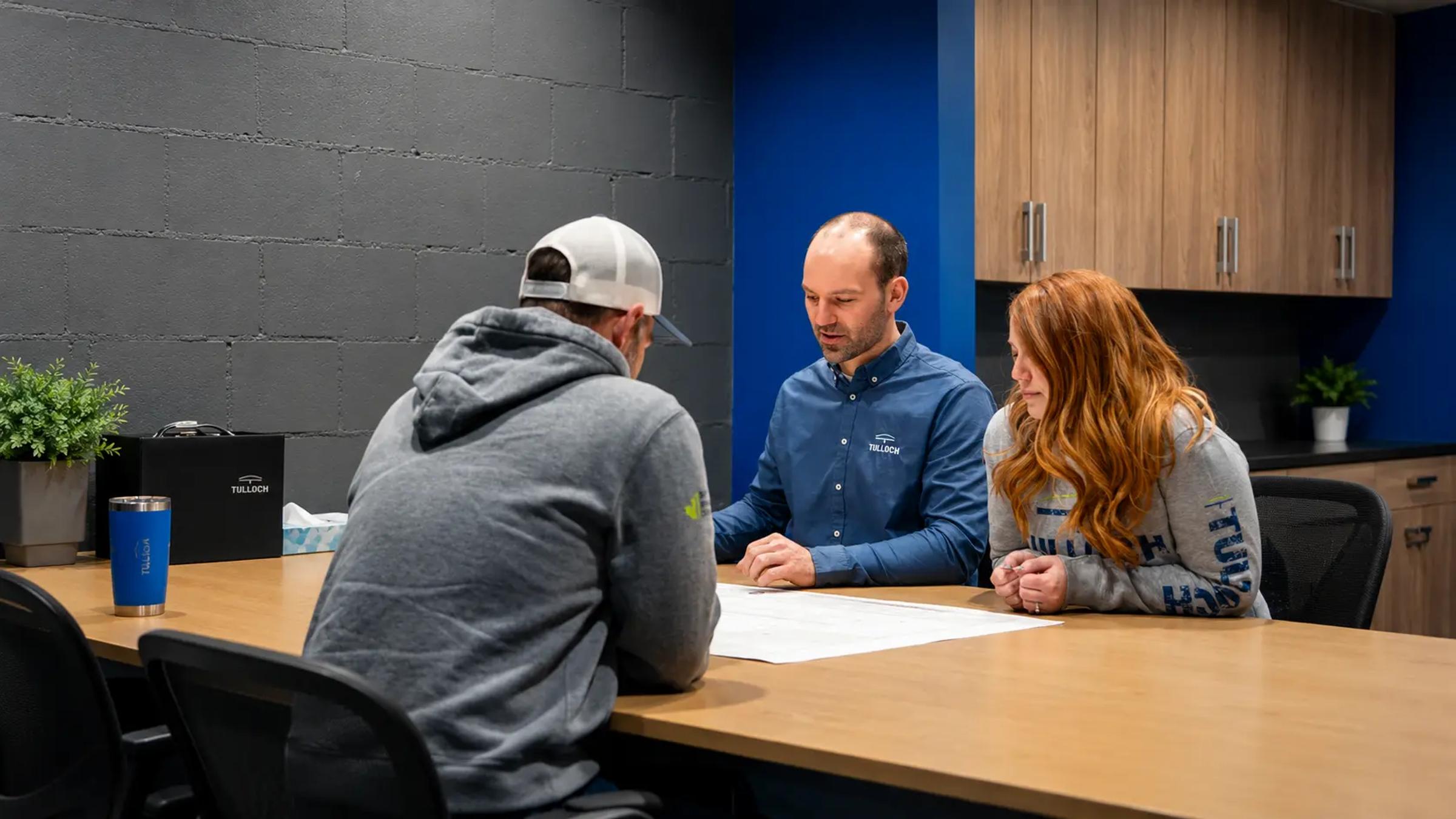 TULLOCH civil engineering team collaborating around a meeting table.