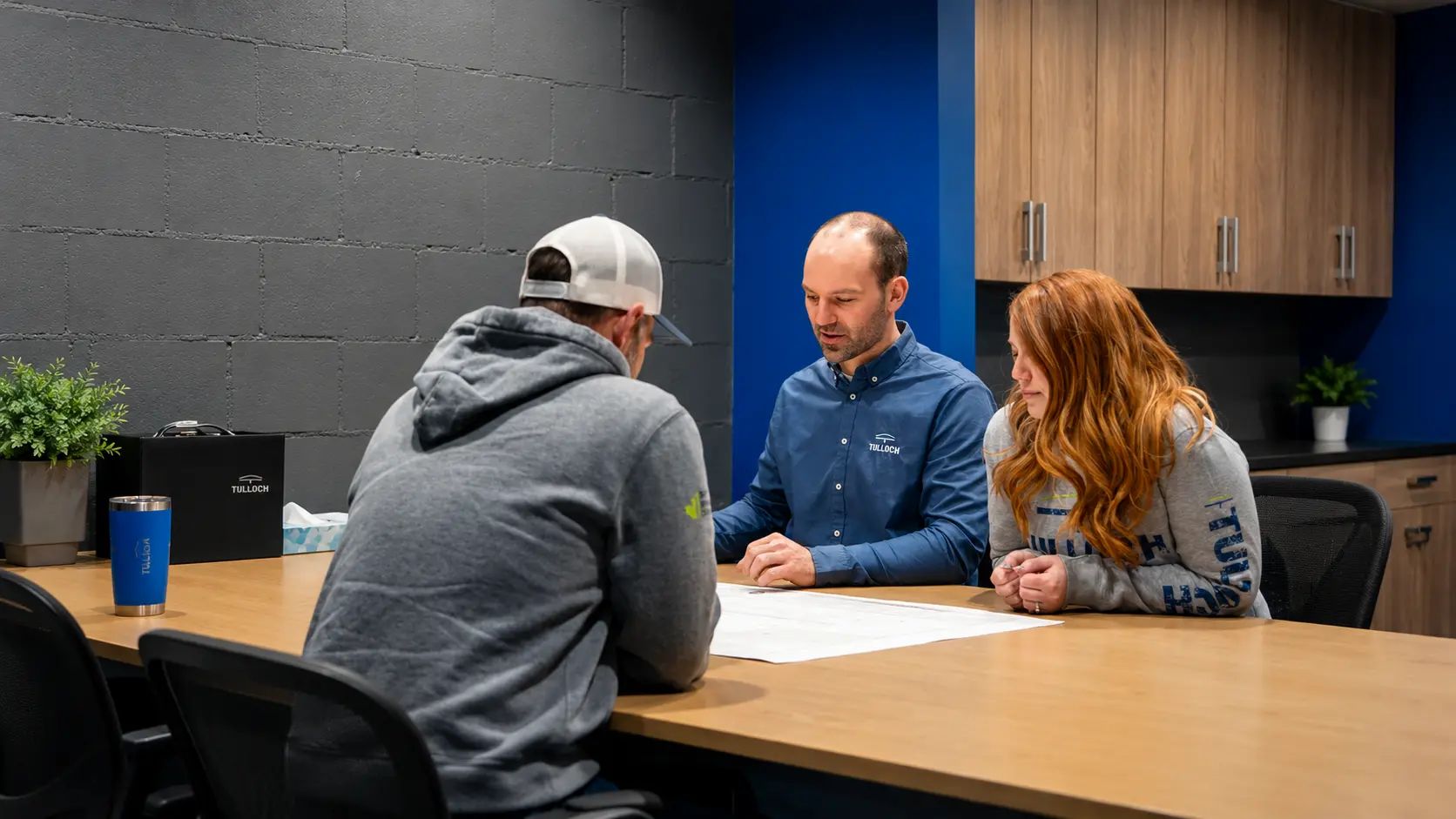 TULLOCH civil engineering team collaborating around a meeting table.