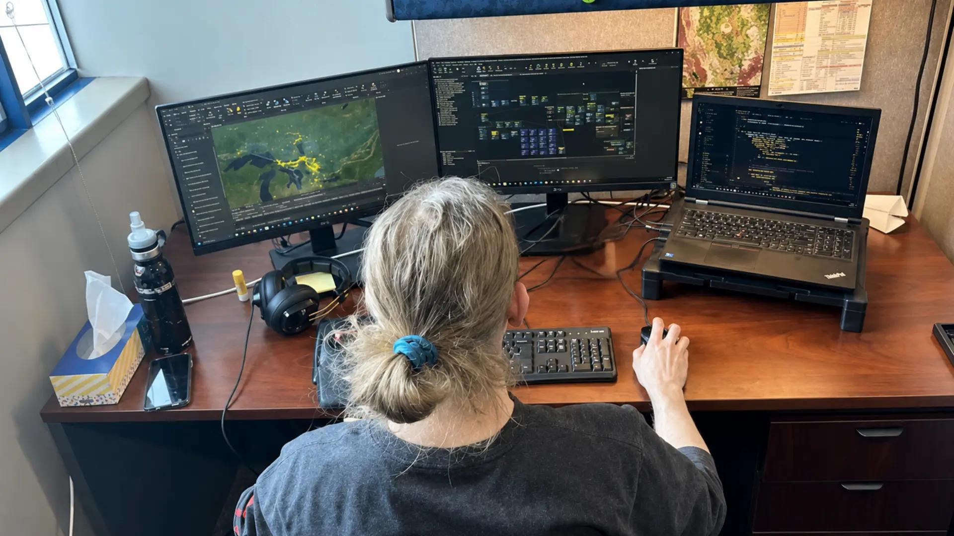 TULLOCH GIS specialist working with mapping data across multiple monitors.