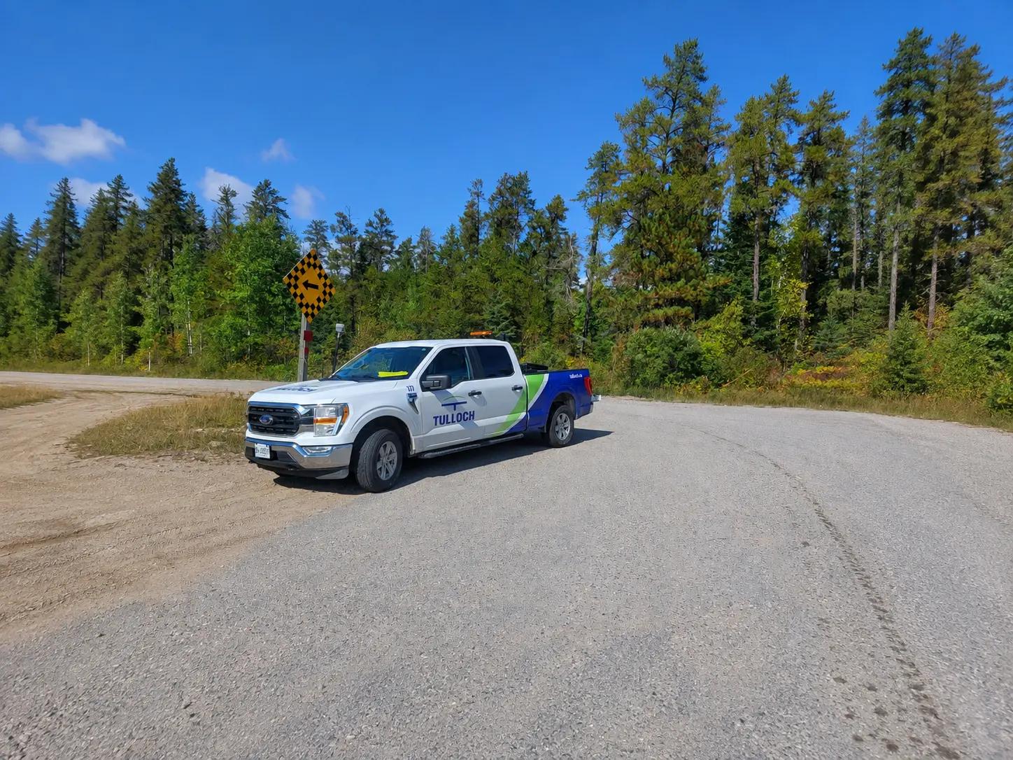 TULLOCH company truck parked on a remote forest road.