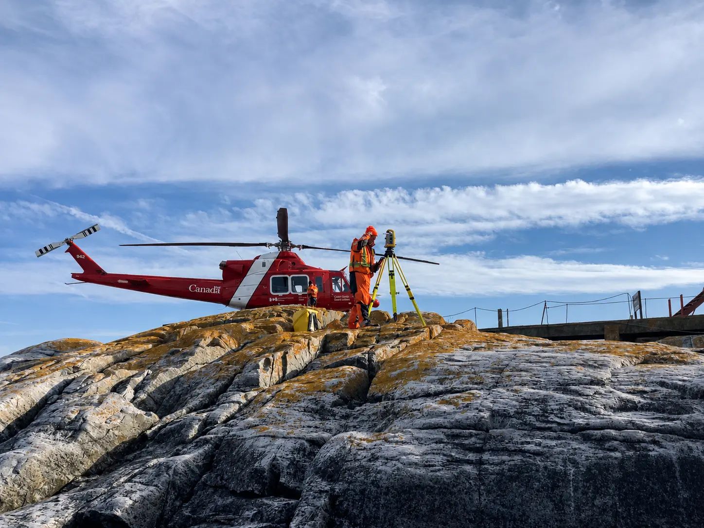 Helicopter positioned on a remote rocky site for field mobilization.