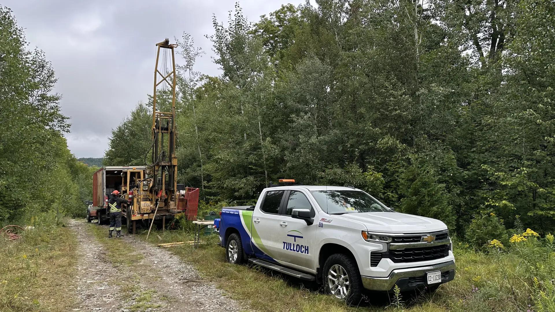 TULLOCH truck and drilling equipment at a energy project site.