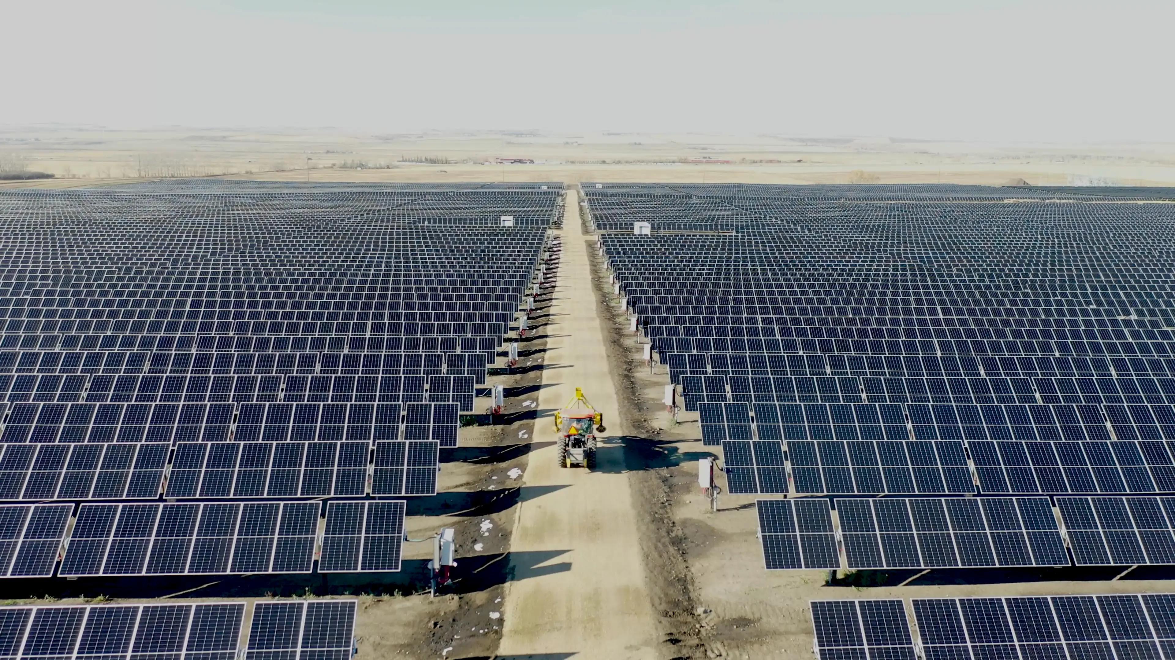 Large utility-scale solar array extending across an open site.