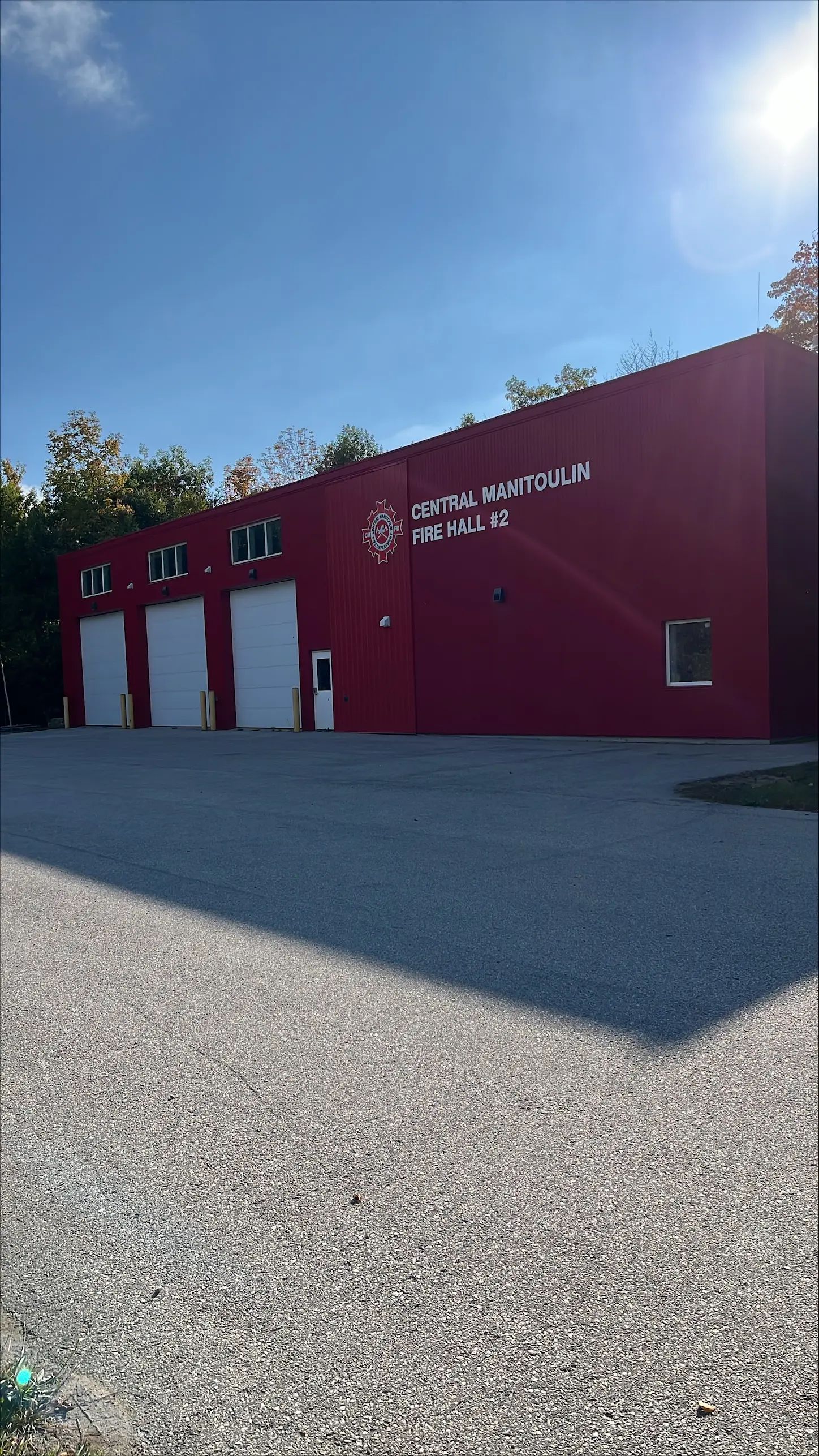 Exterior view of a fire hall building and paved access area.