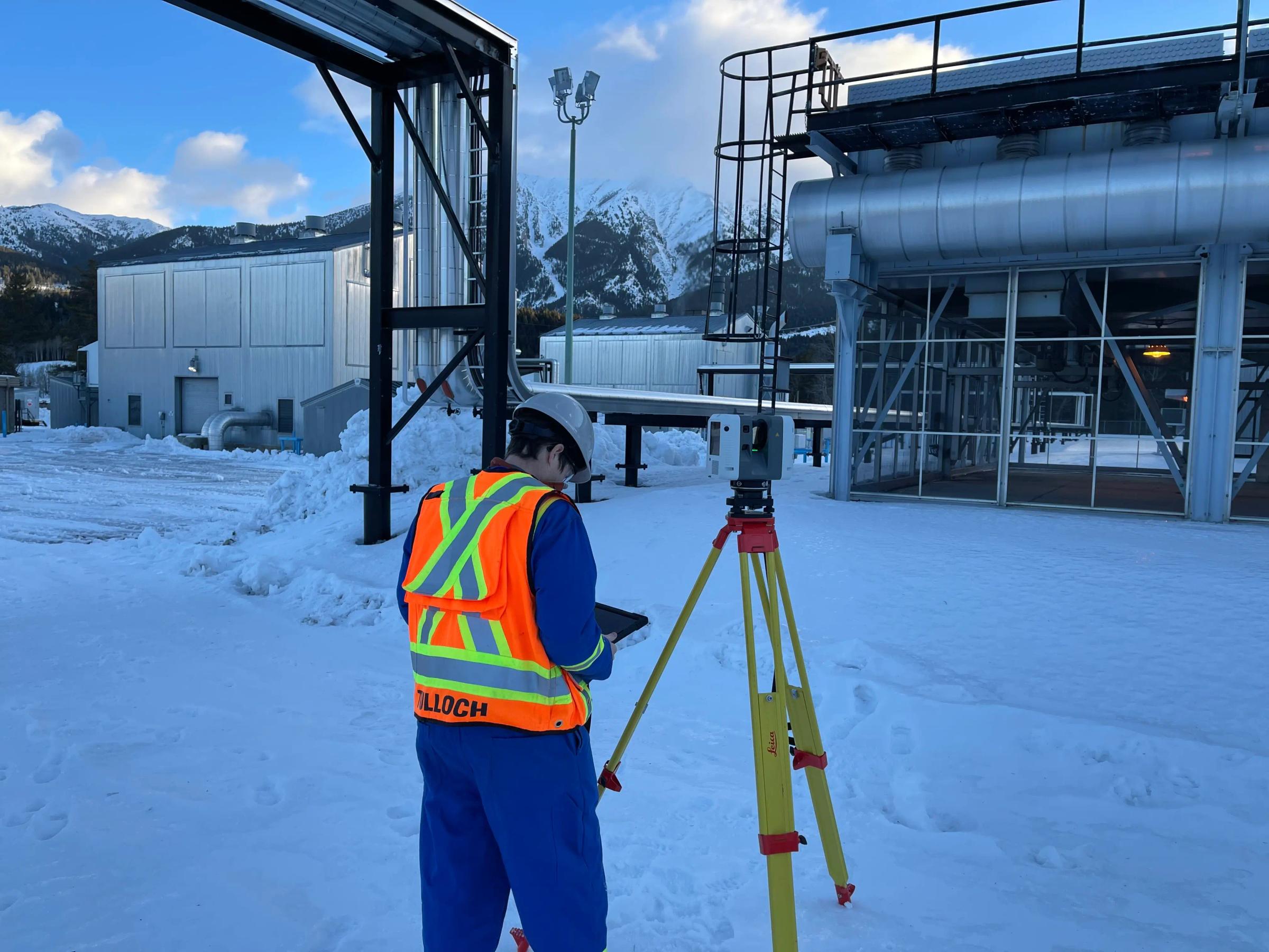 TULLOCH survey technician collecting field data at a winter construction site.