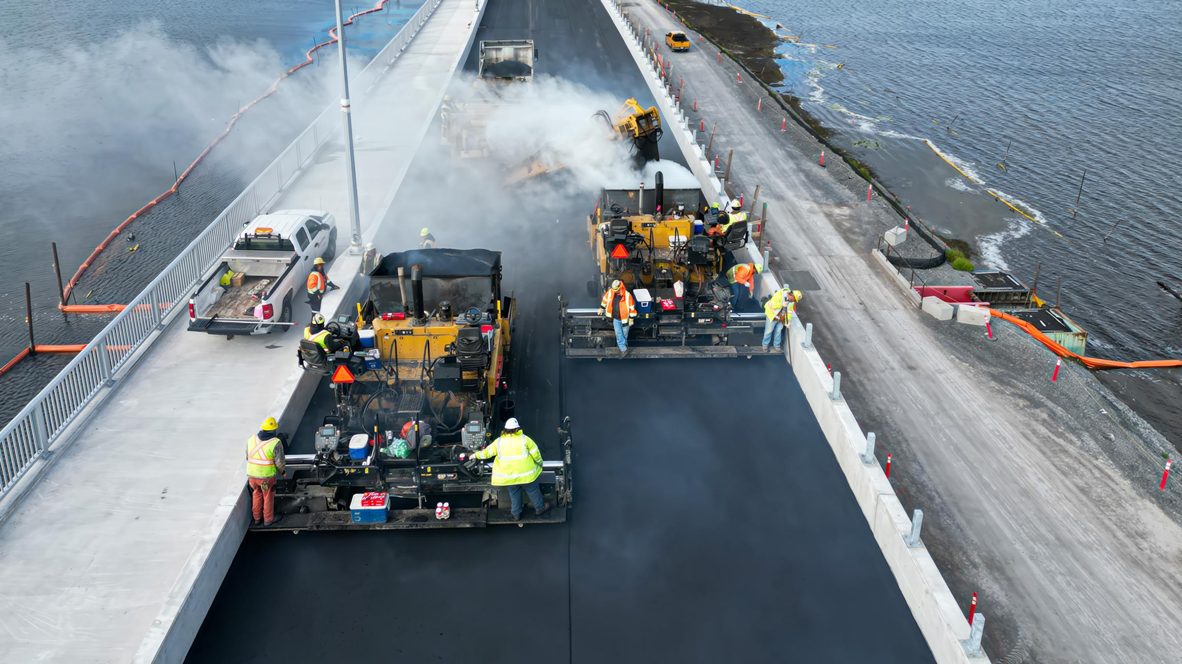 Aerial view of active bridge deck construction over a water crossing.