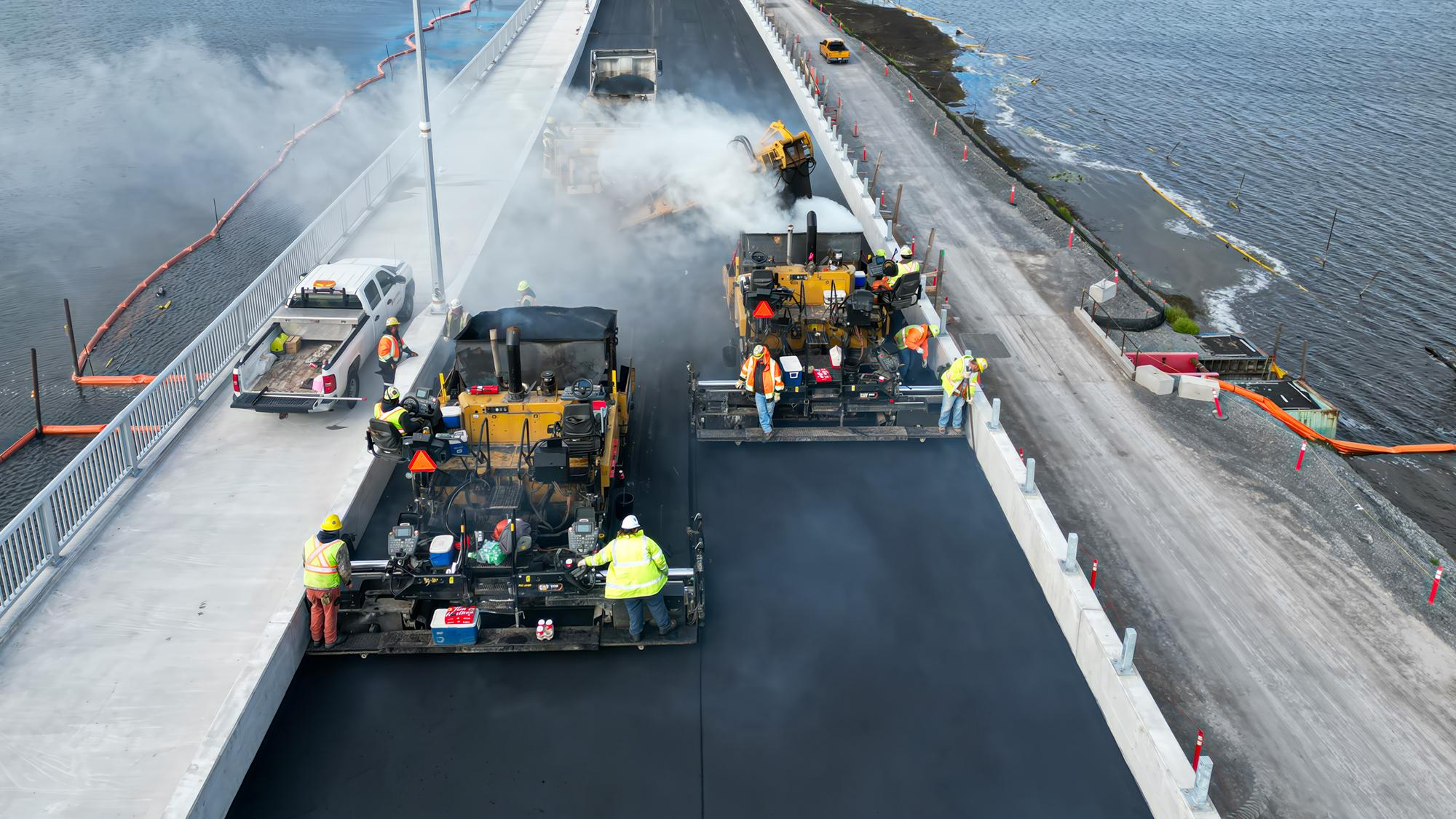 Aerial view of active bridge deck construction over a water crossing.