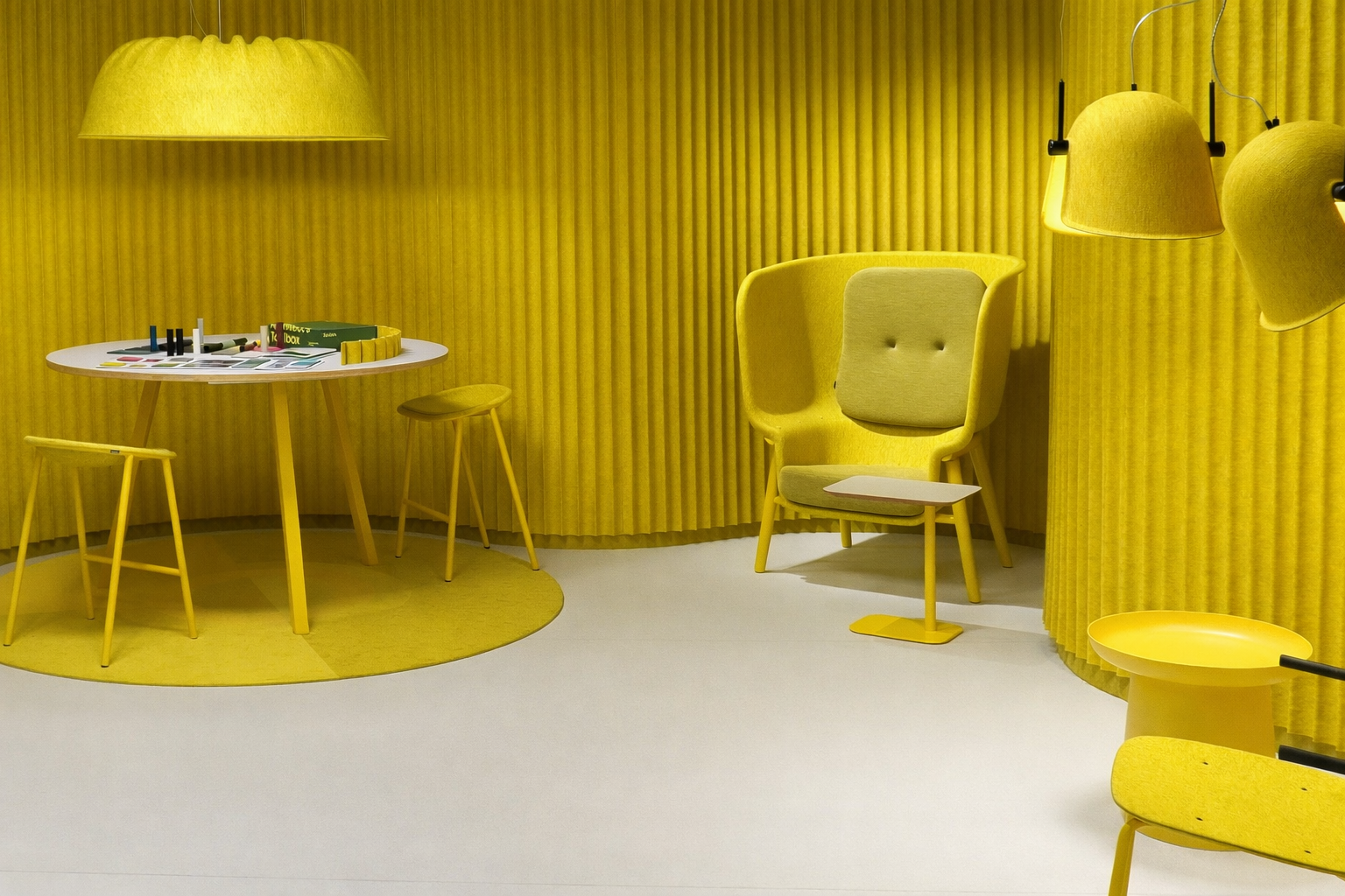 De Vorm collection in yellow, featuring lounge chairs, acoustic Mute panels, and pendant lamps in a showroom setting