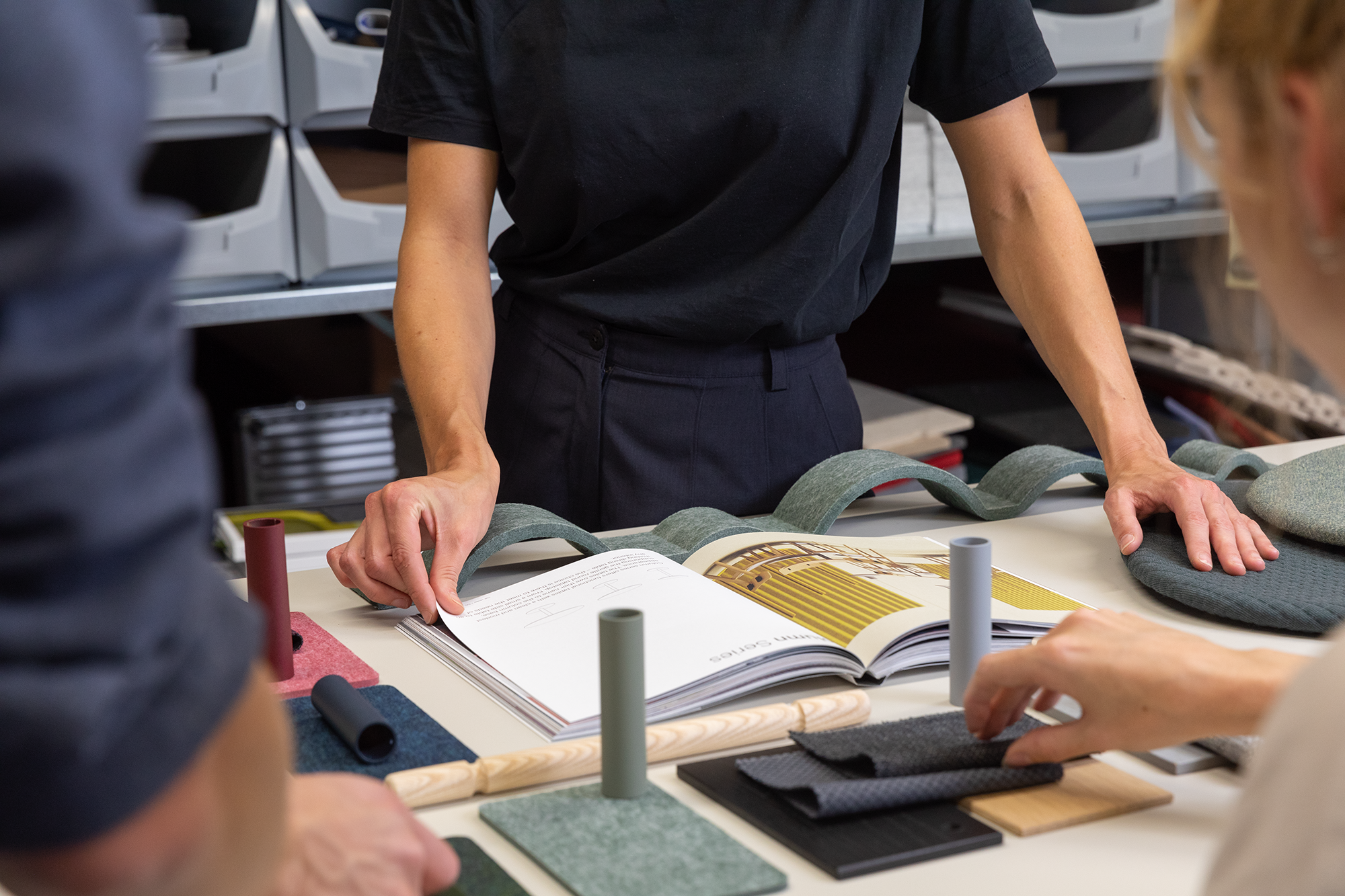 De Vorm design team reviewing PET felt material samples and a product catalogue on a studio worktable