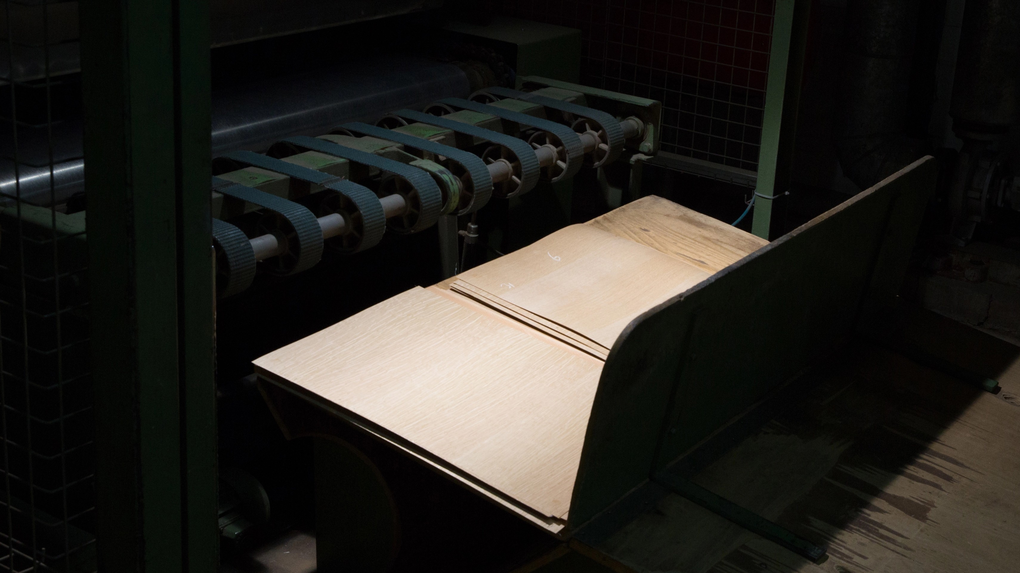 Engineered plywood sheets being processed through a production machine for De Vorm wood furniture components