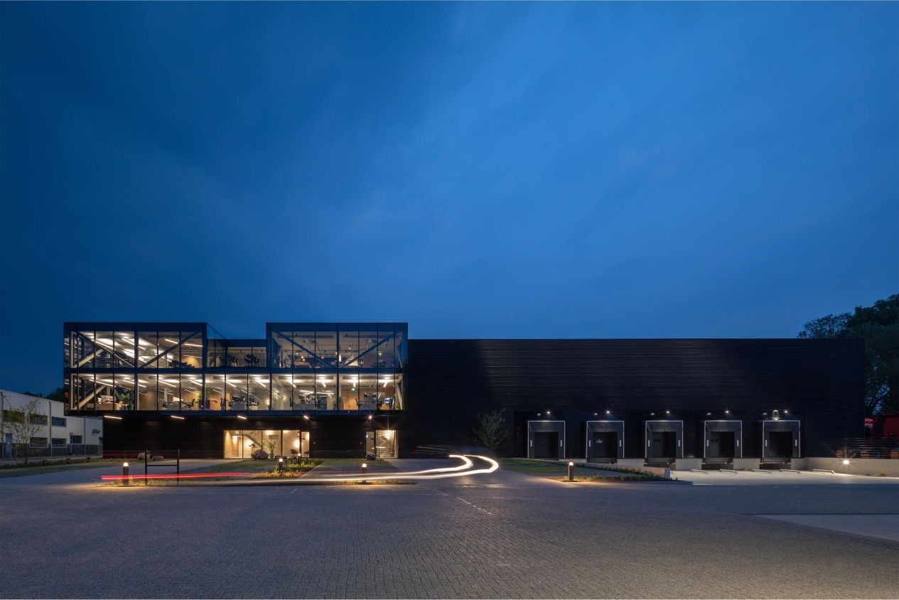 De Vorm headquarters in Duiven, the Netherlands, exterior at night with illuminated office and production facility