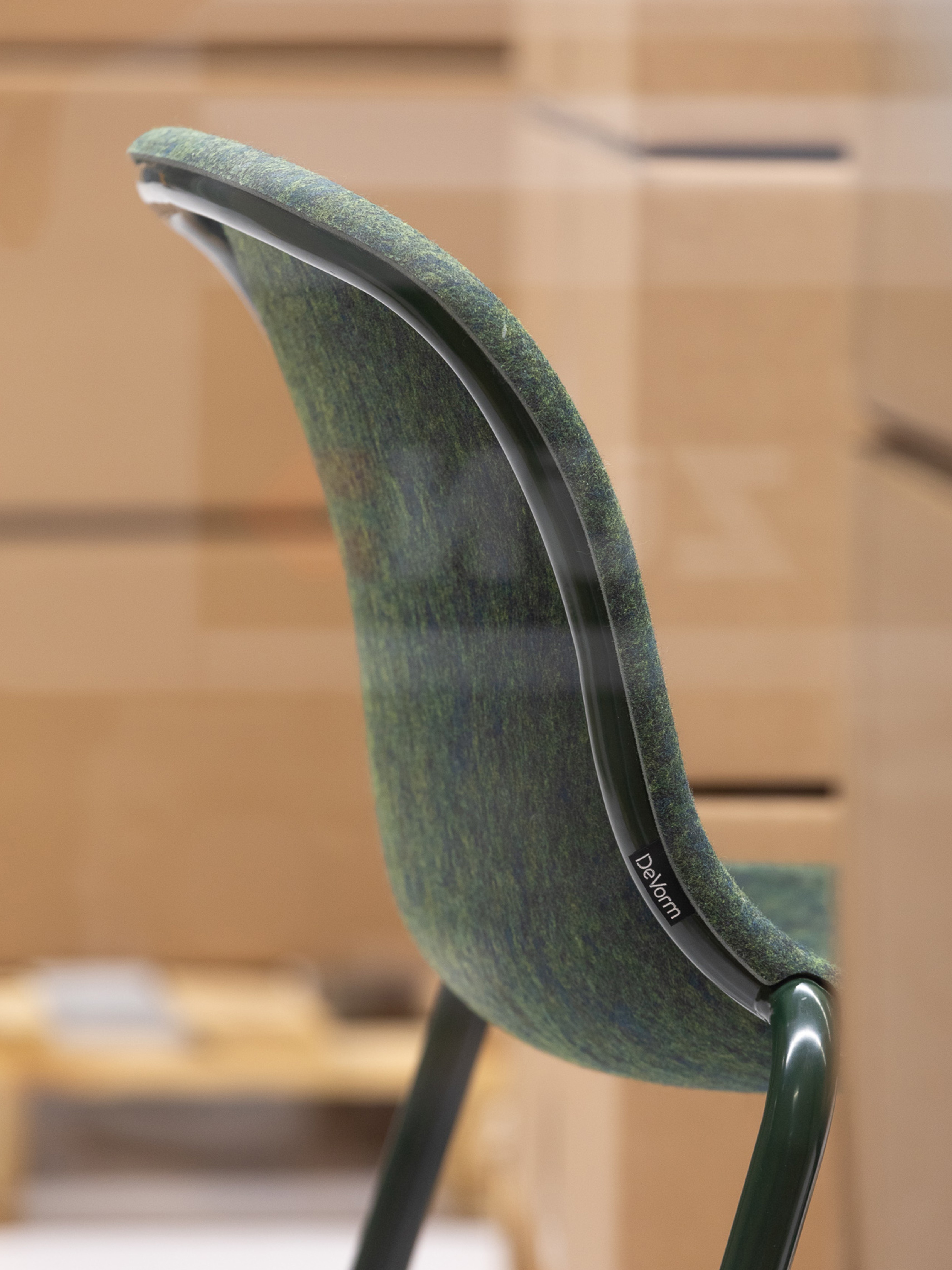 LJ 2 PET Felt Stack Chair in olive green with dark green frame, close-up of backrest in a warehouse setting