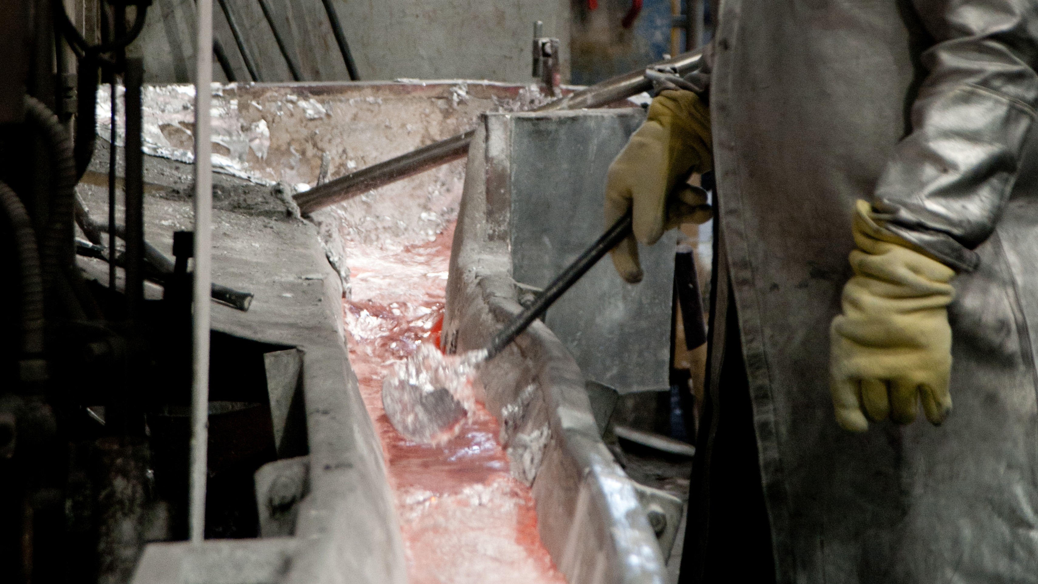 Molten circular aluminium being poured and guided by a production worker, ready for reuse in De Vorm furniture frames
